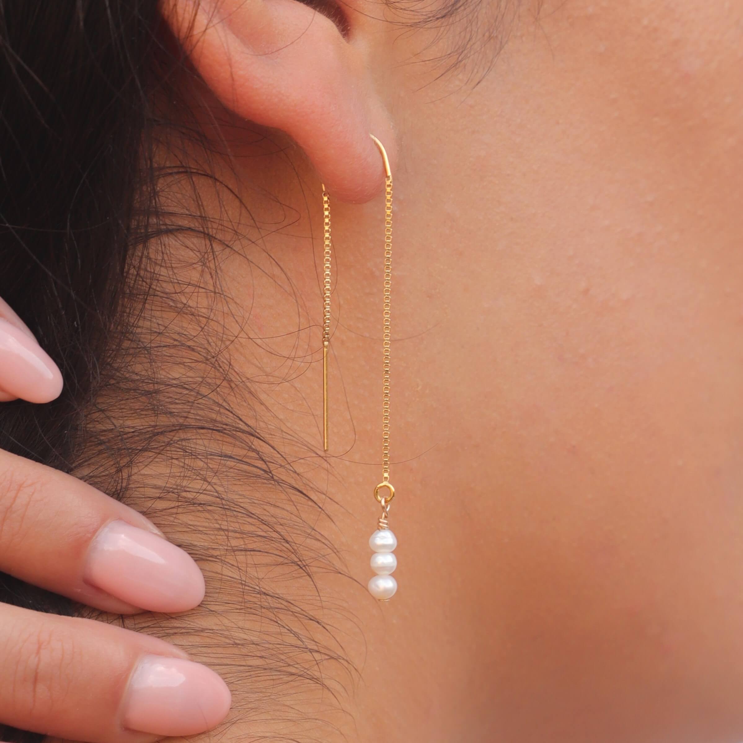 tiny pearl threader earrings in gold filled close up on model