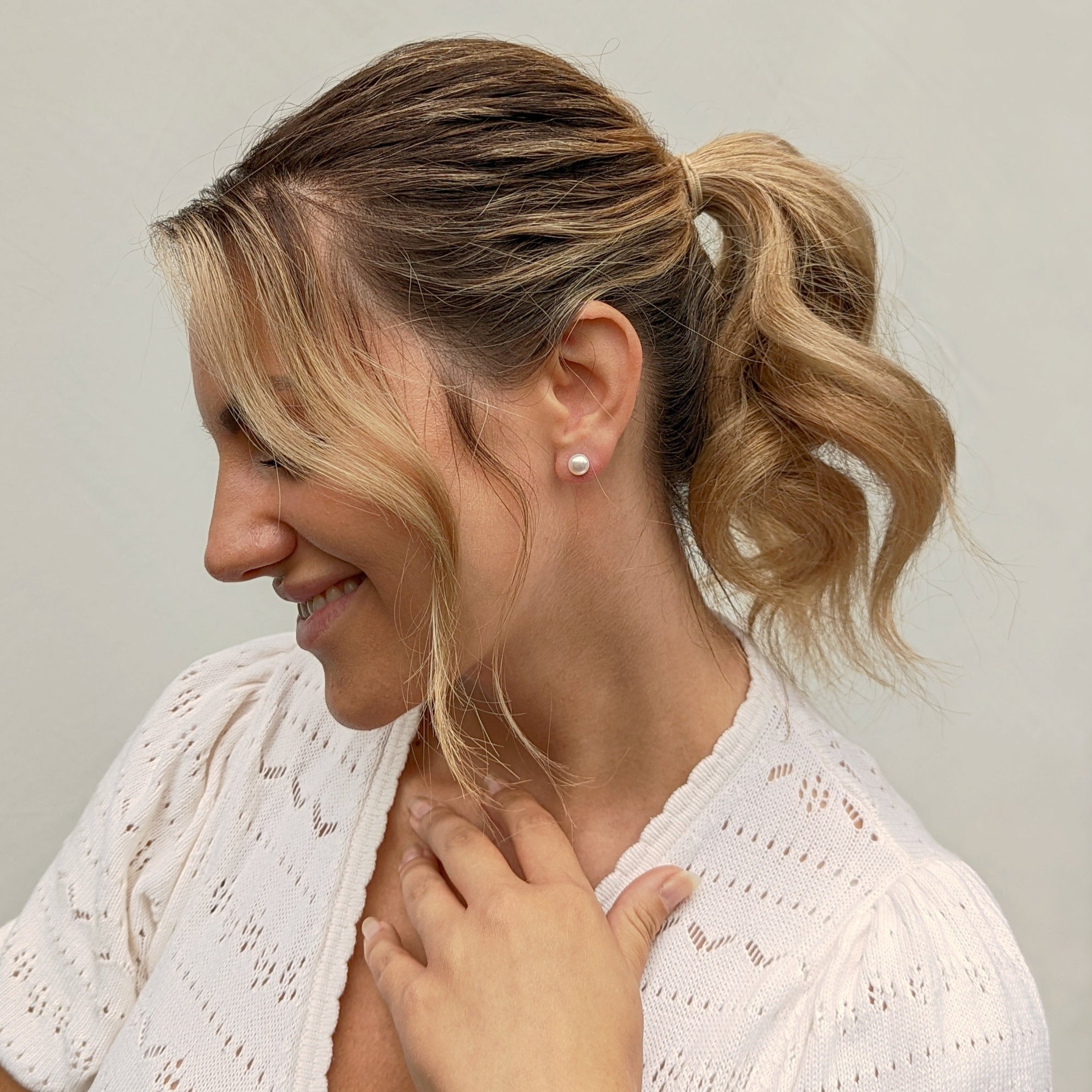 Model wearing a single button pearl stud earring