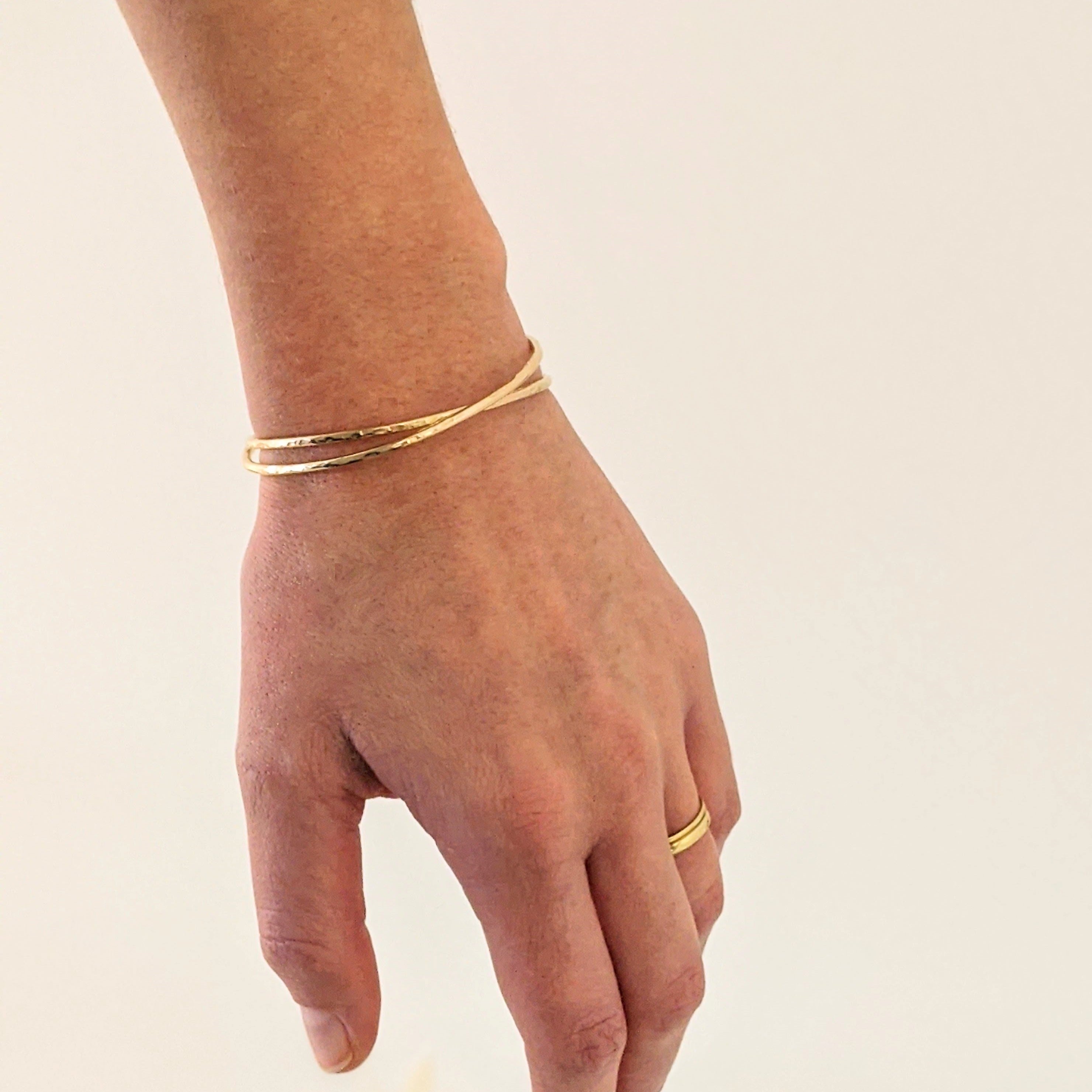 Hammered gold cuff bracelets on model wrist