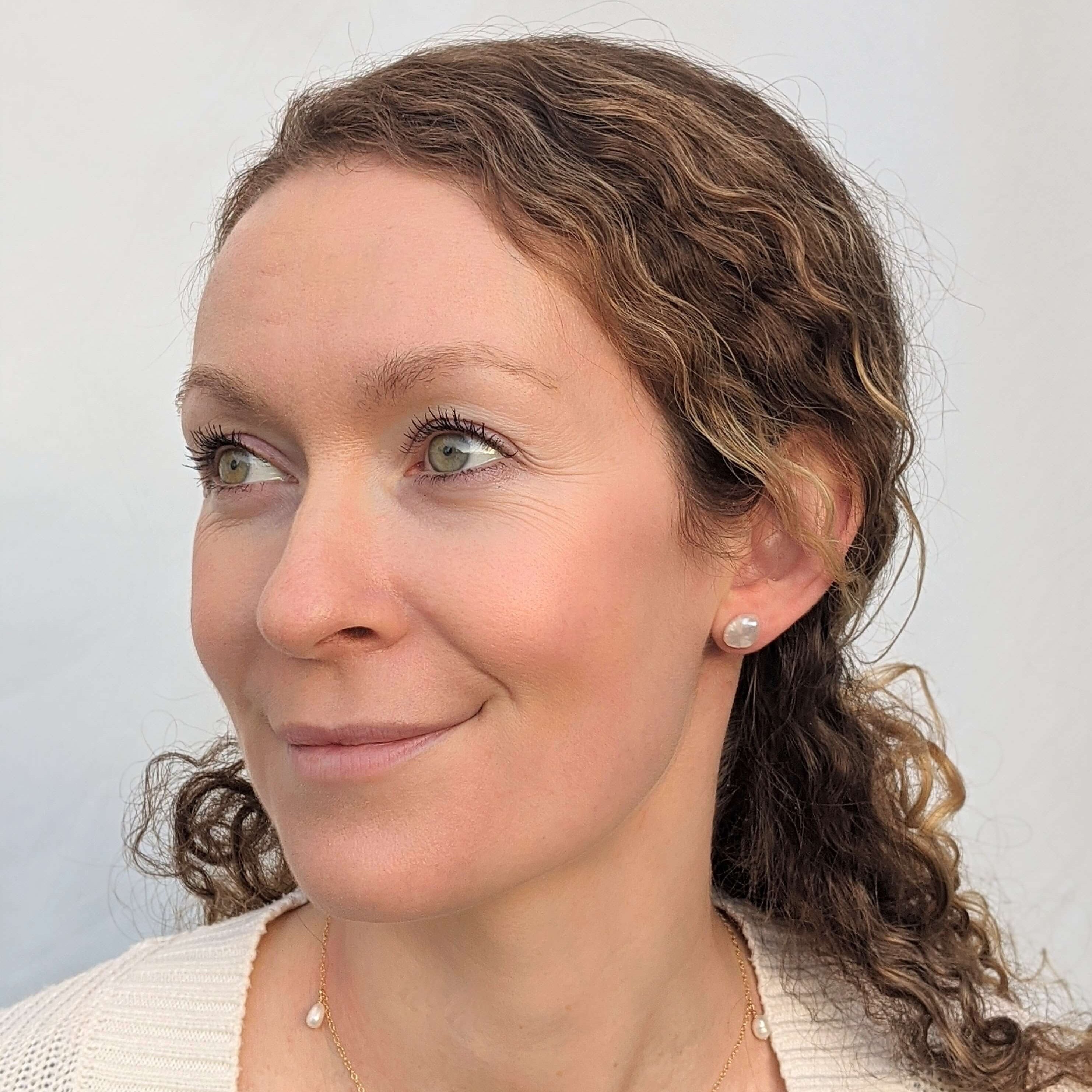 Woman wearing irregular keshi pearl earrings and a pearl necklace