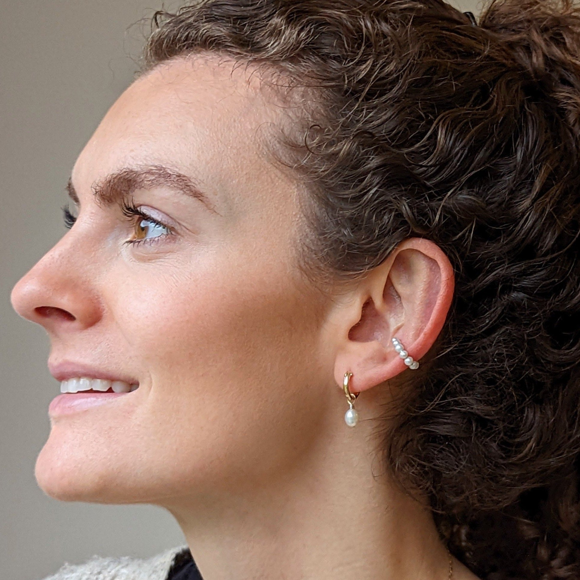 Side shot of model wearing pearl earrings