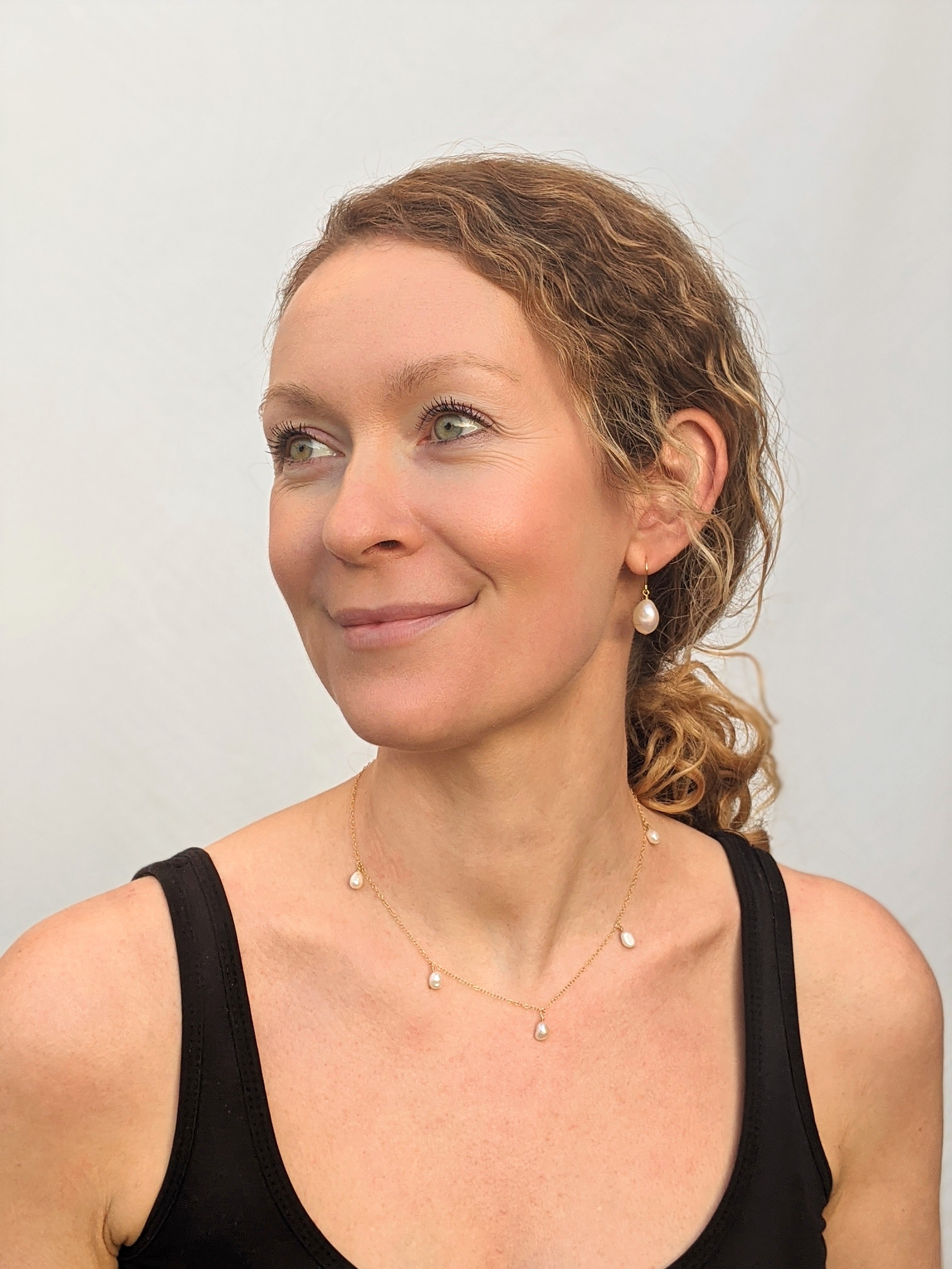 model wearing pearl hook earrings and five pearl necklace