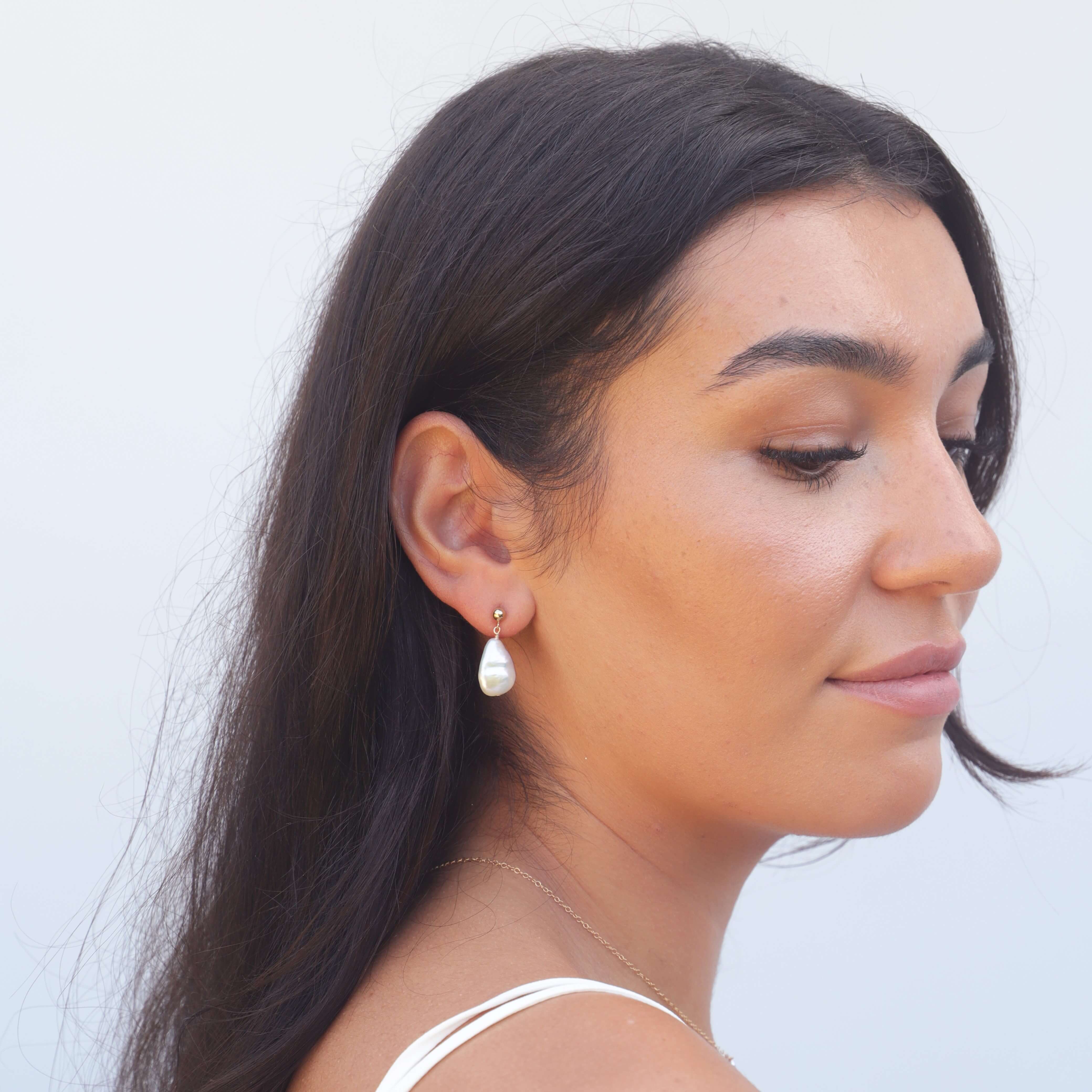 Headshot of model wearing teardrop shaped pearl earring
