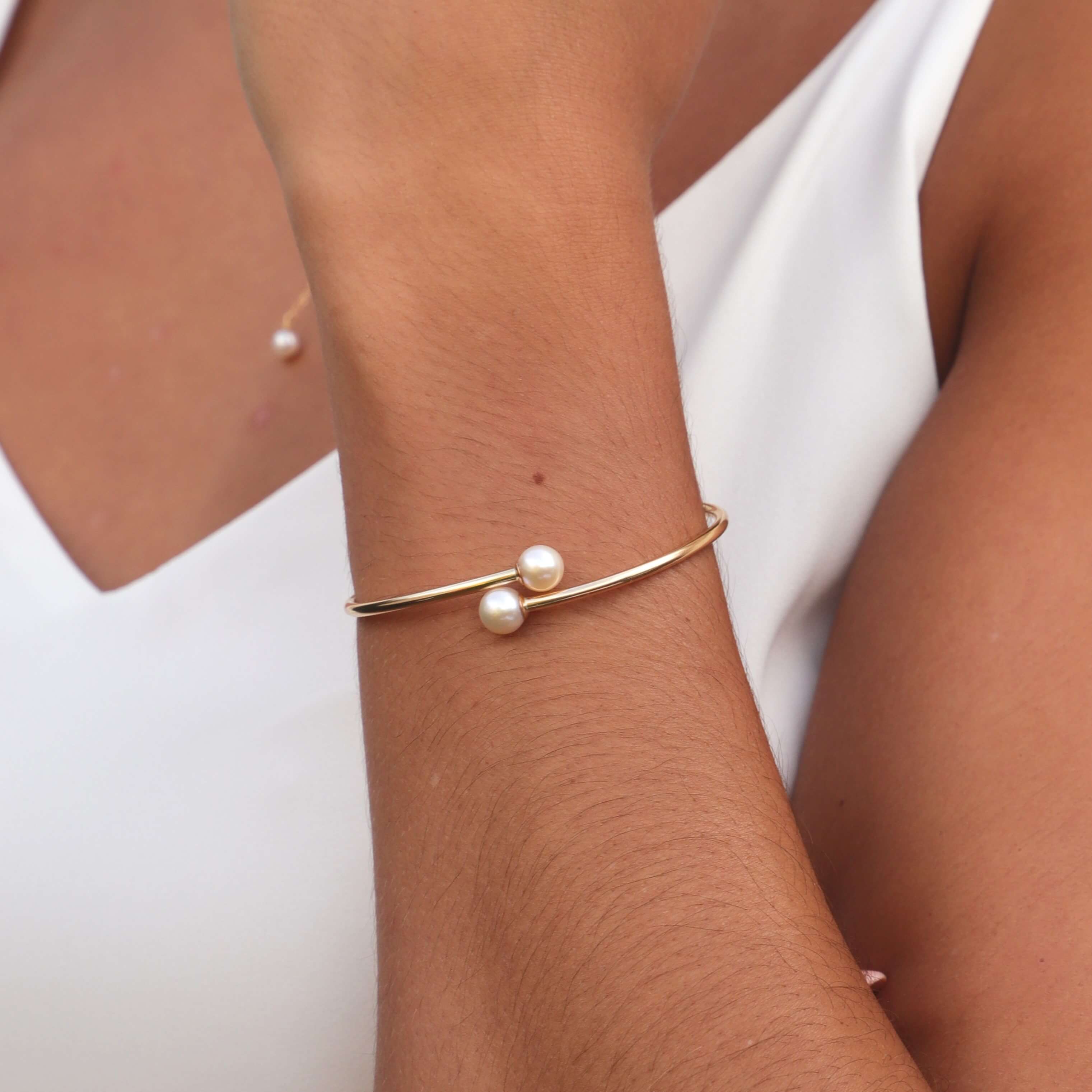 close up shot of gold pearl bangle on model wrist