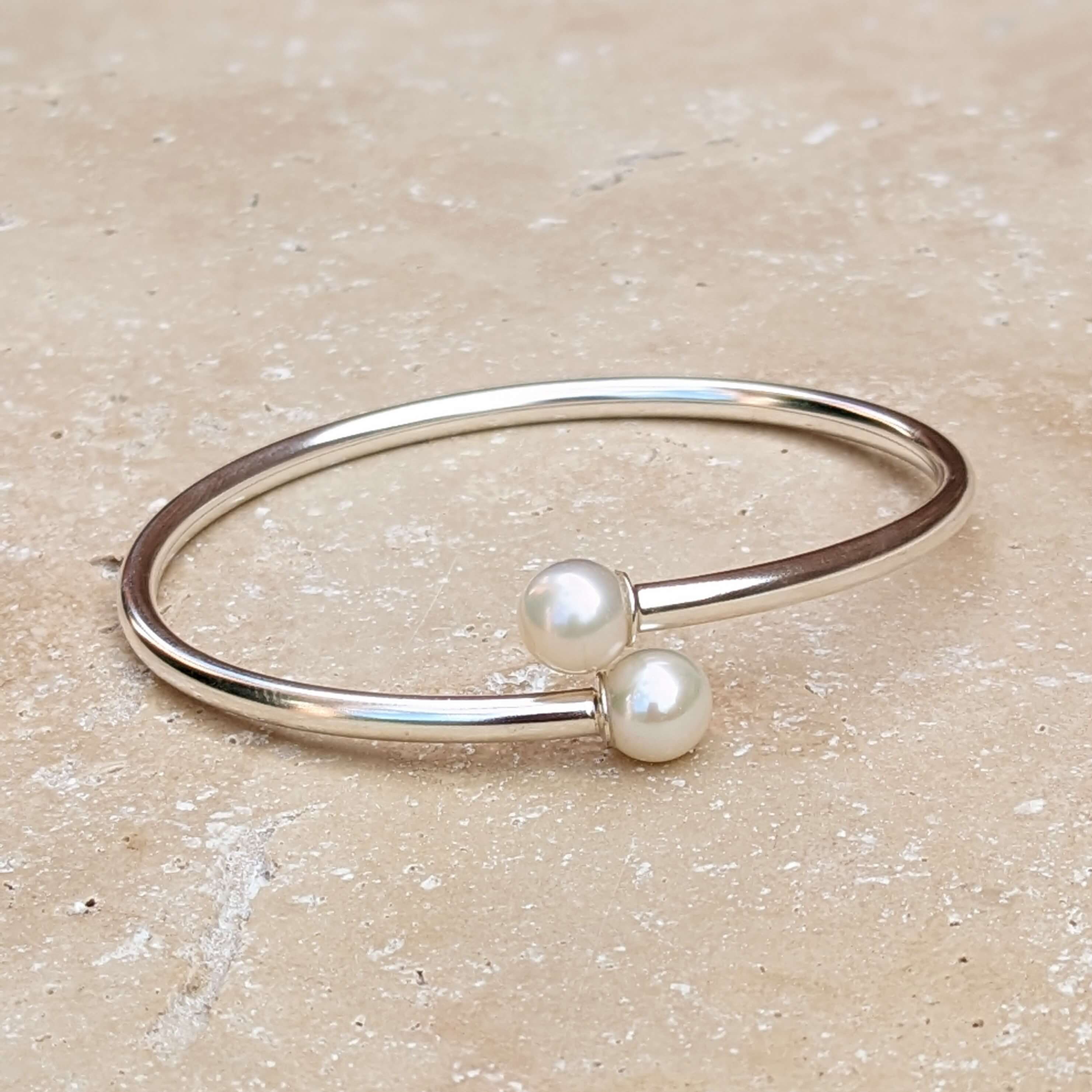 sterling silver pearl bangle on background