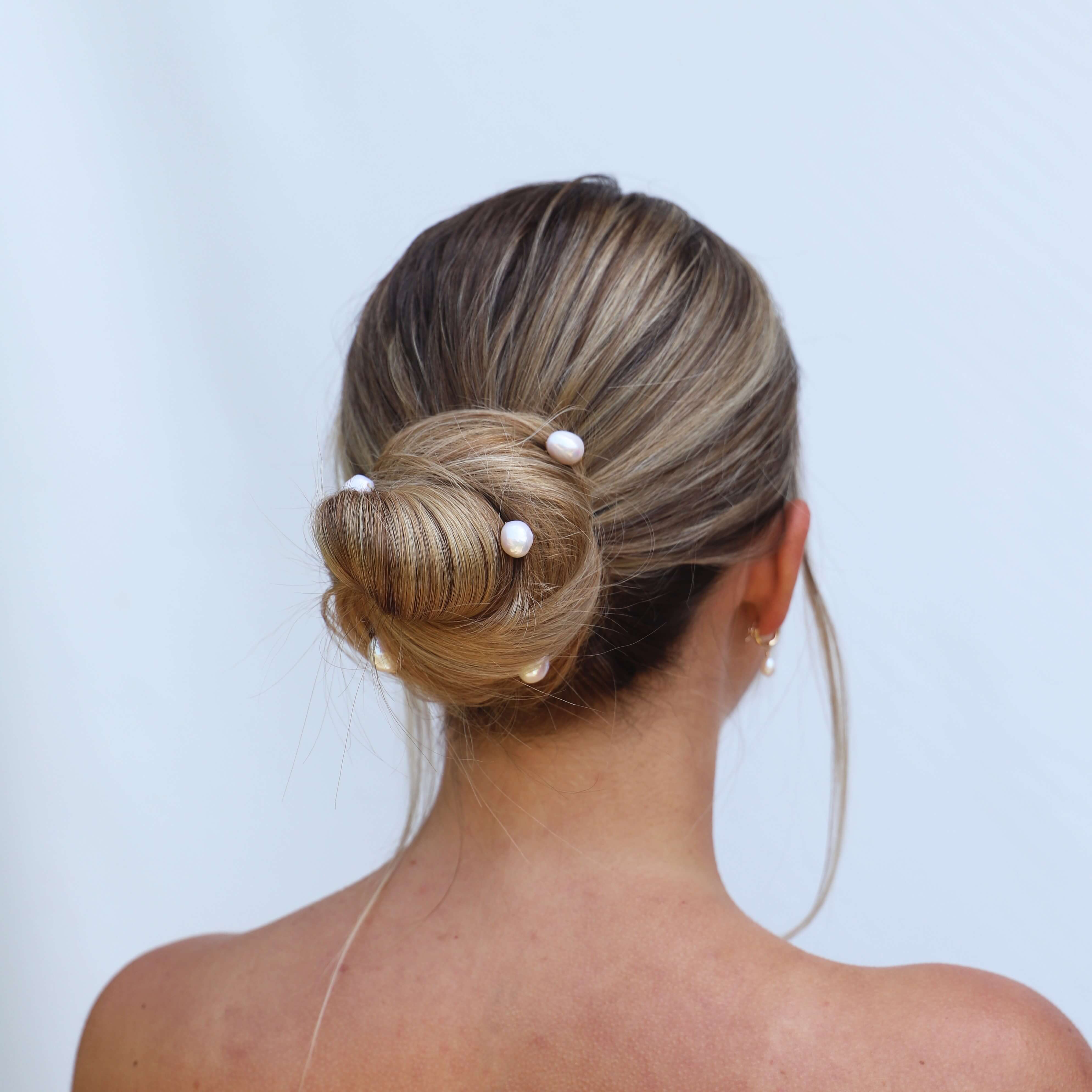 Back of wedding model with hair up with white baroque pearl pins