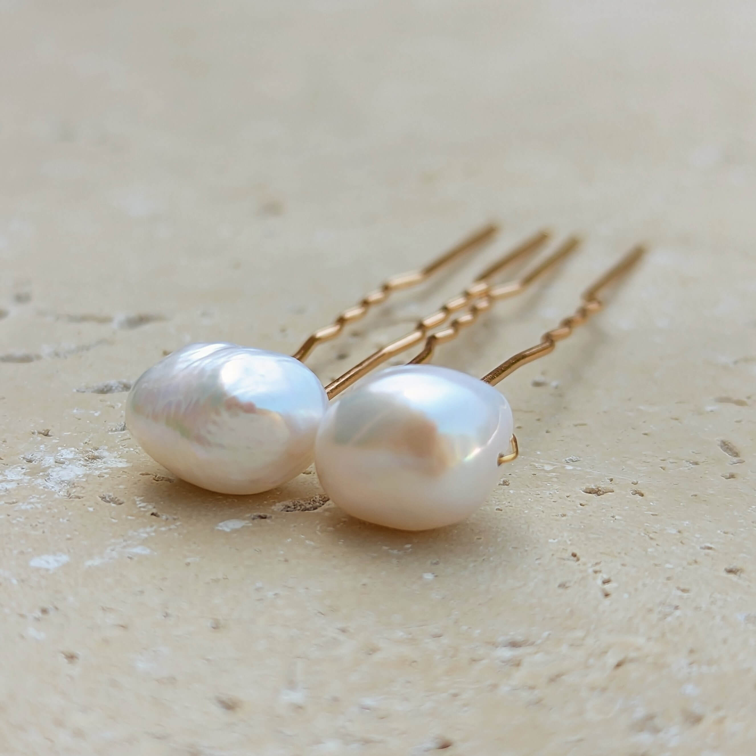 Two large baroque pearl hair pins with gold coloured metal