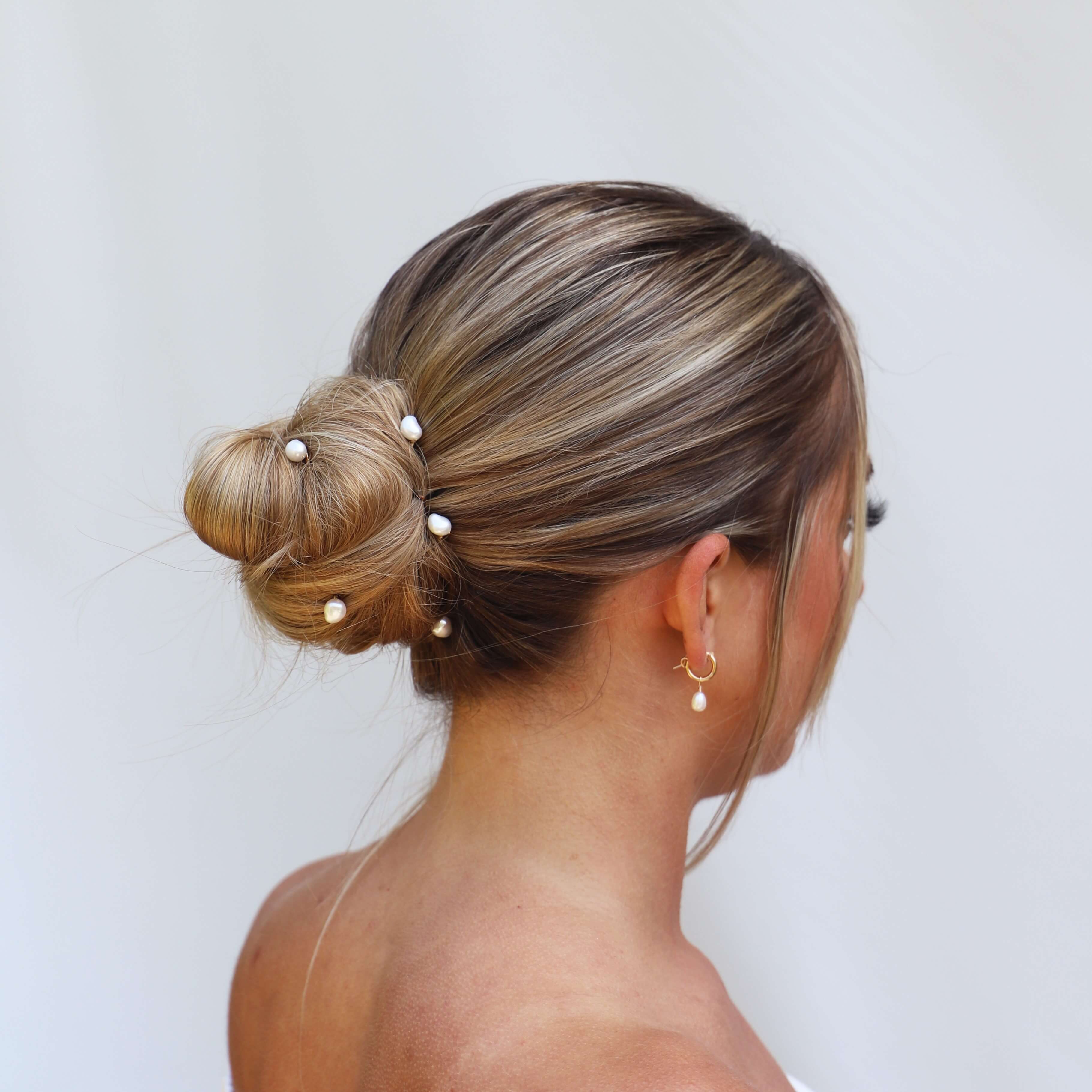 Bride wearing real pearl hair pins and pearl hoop earrings