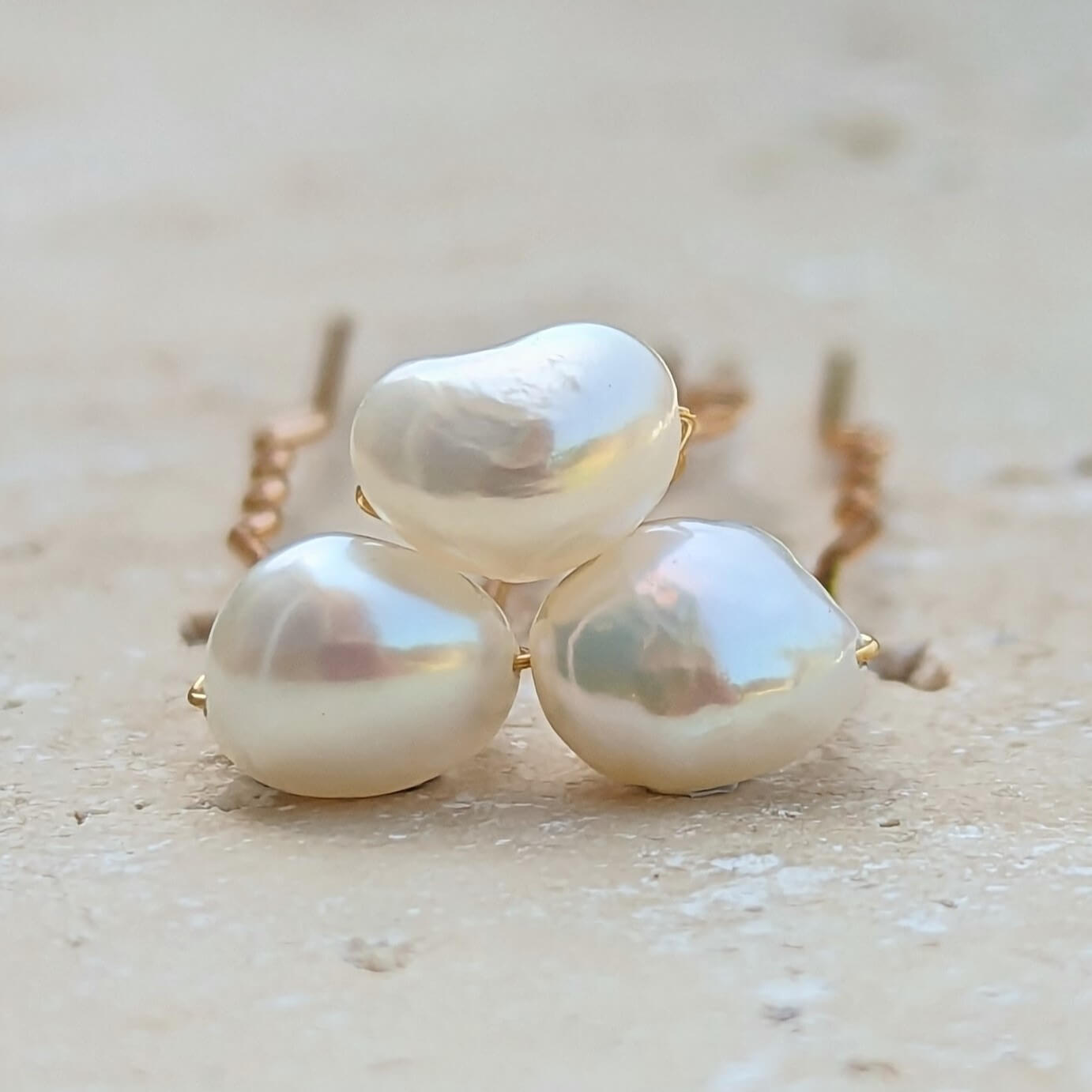 three medium real freshwater pearls on gold coloured hair pins