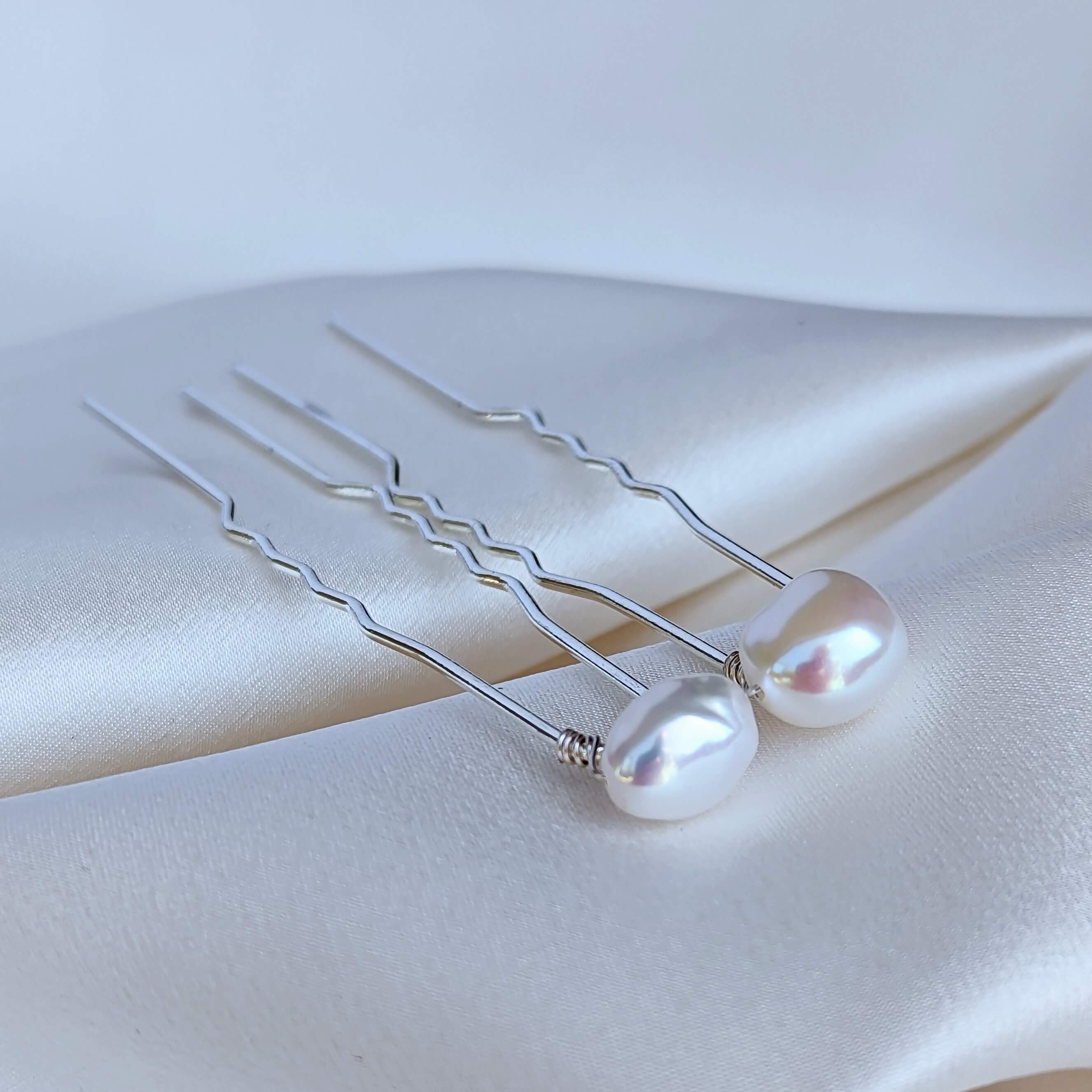 two medium sized real freshwater pearls on silver coloured hair pins