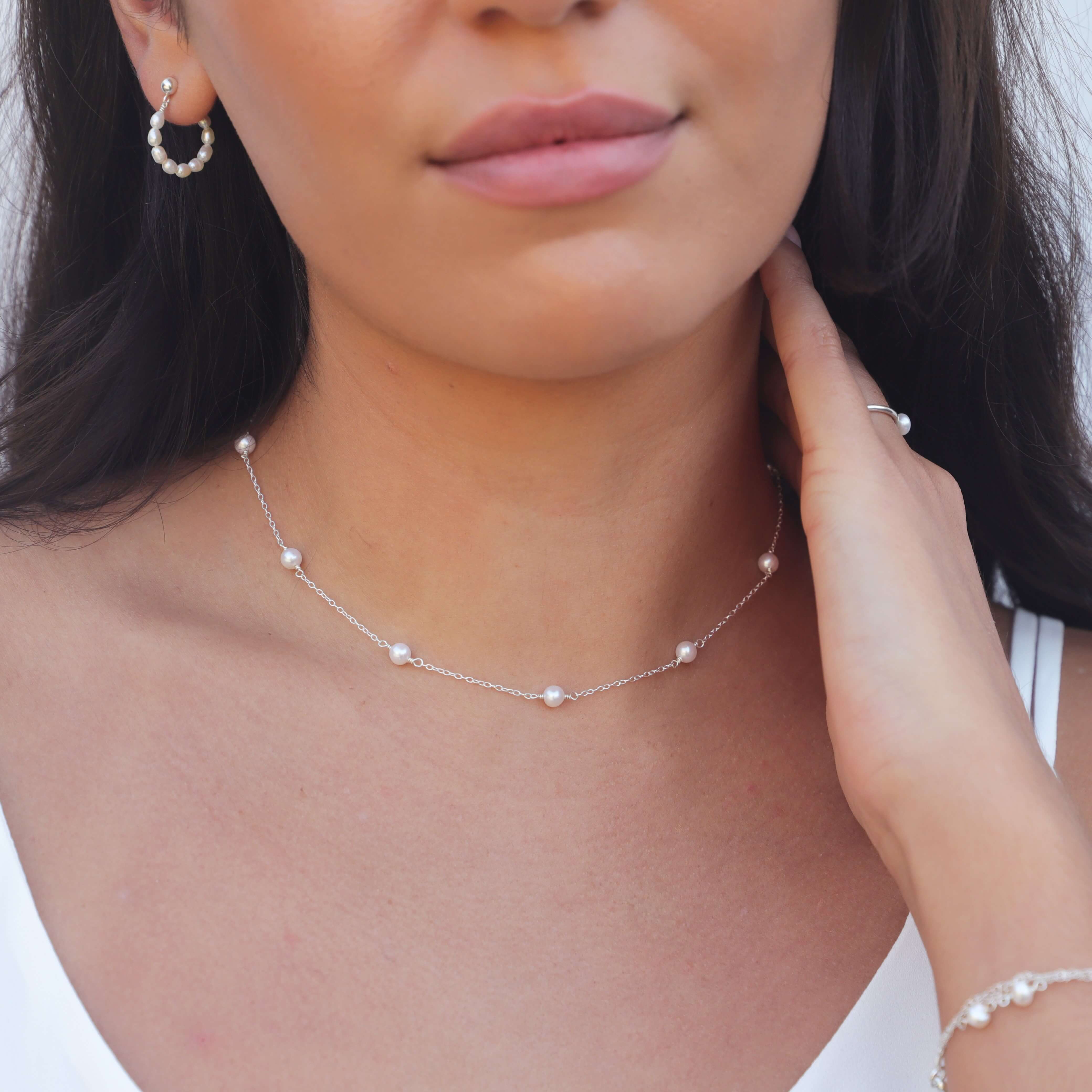 pearl and sterling silver chain necklace on model posing with hand