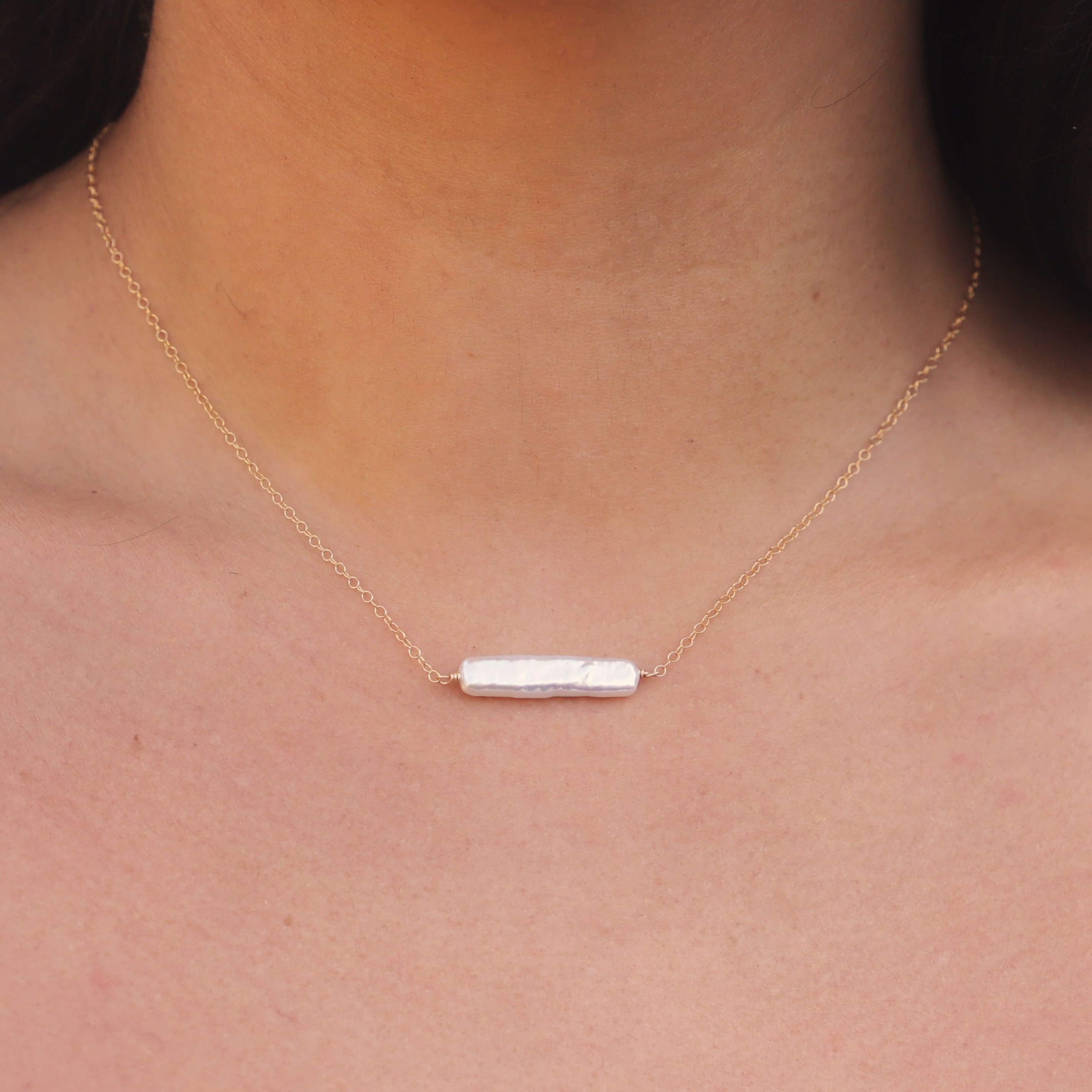Model's neck with rectangular shaped pearl on fine gold chain