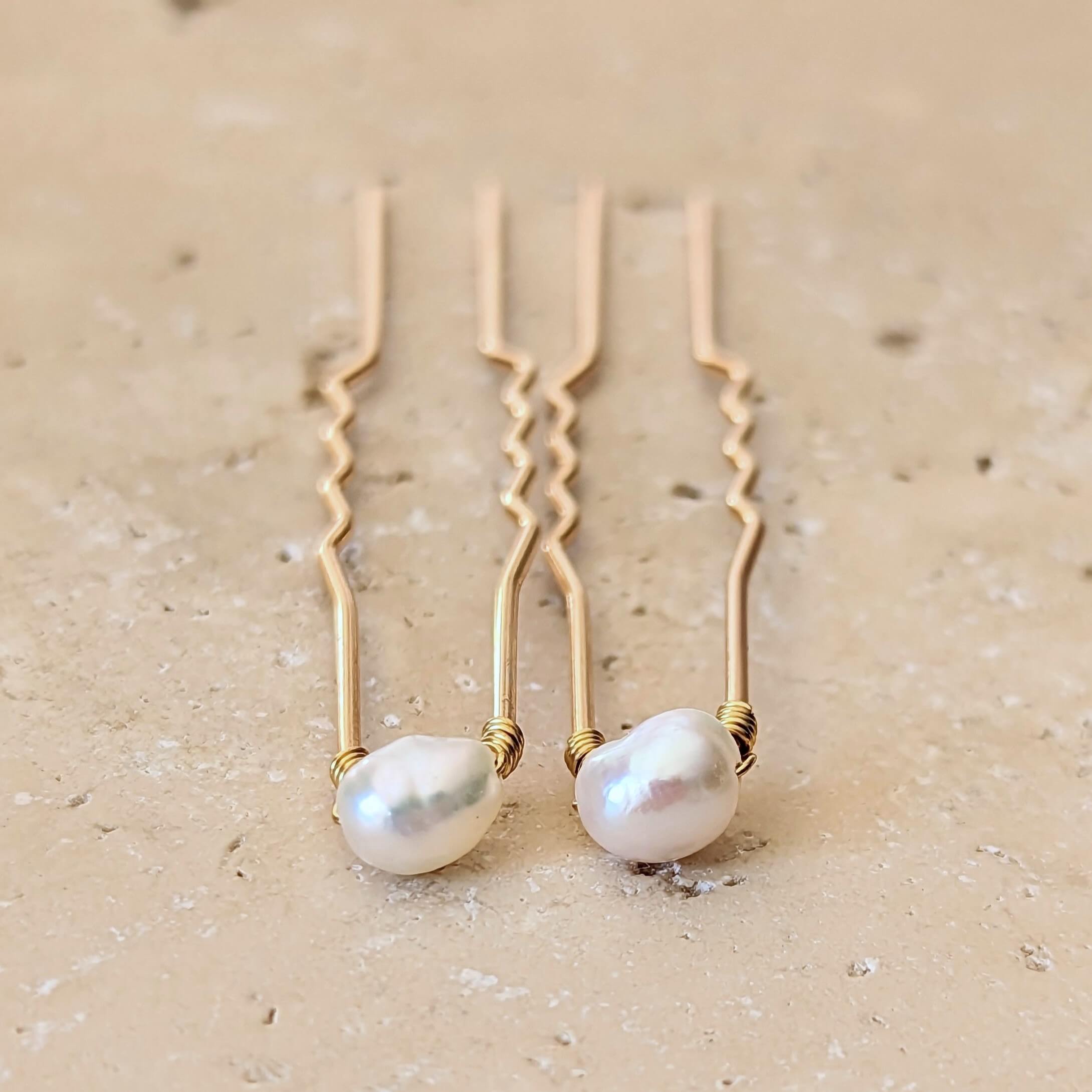 two small pearl hair pins in gold