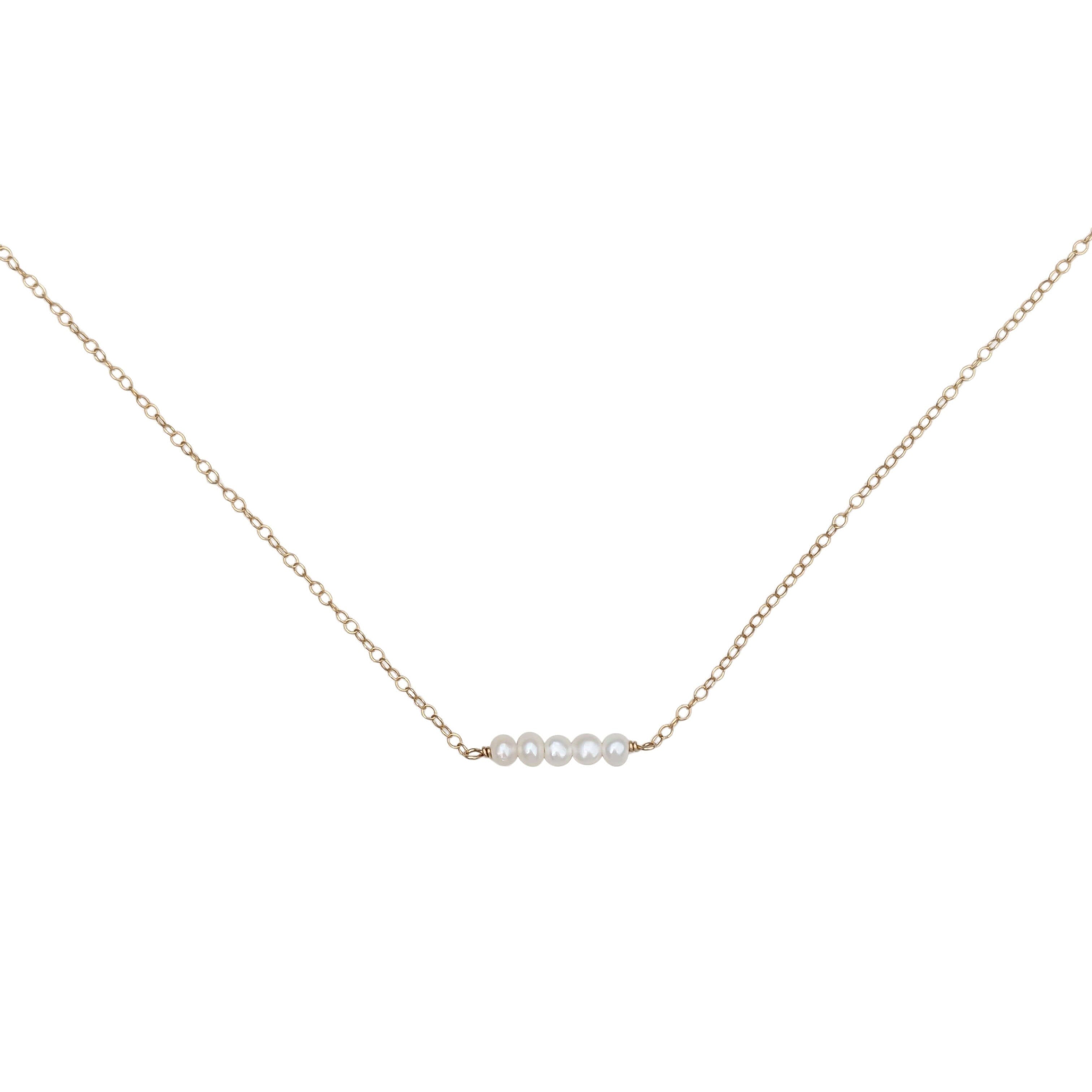 tiny pearl bar necklace in gold filled on a white background