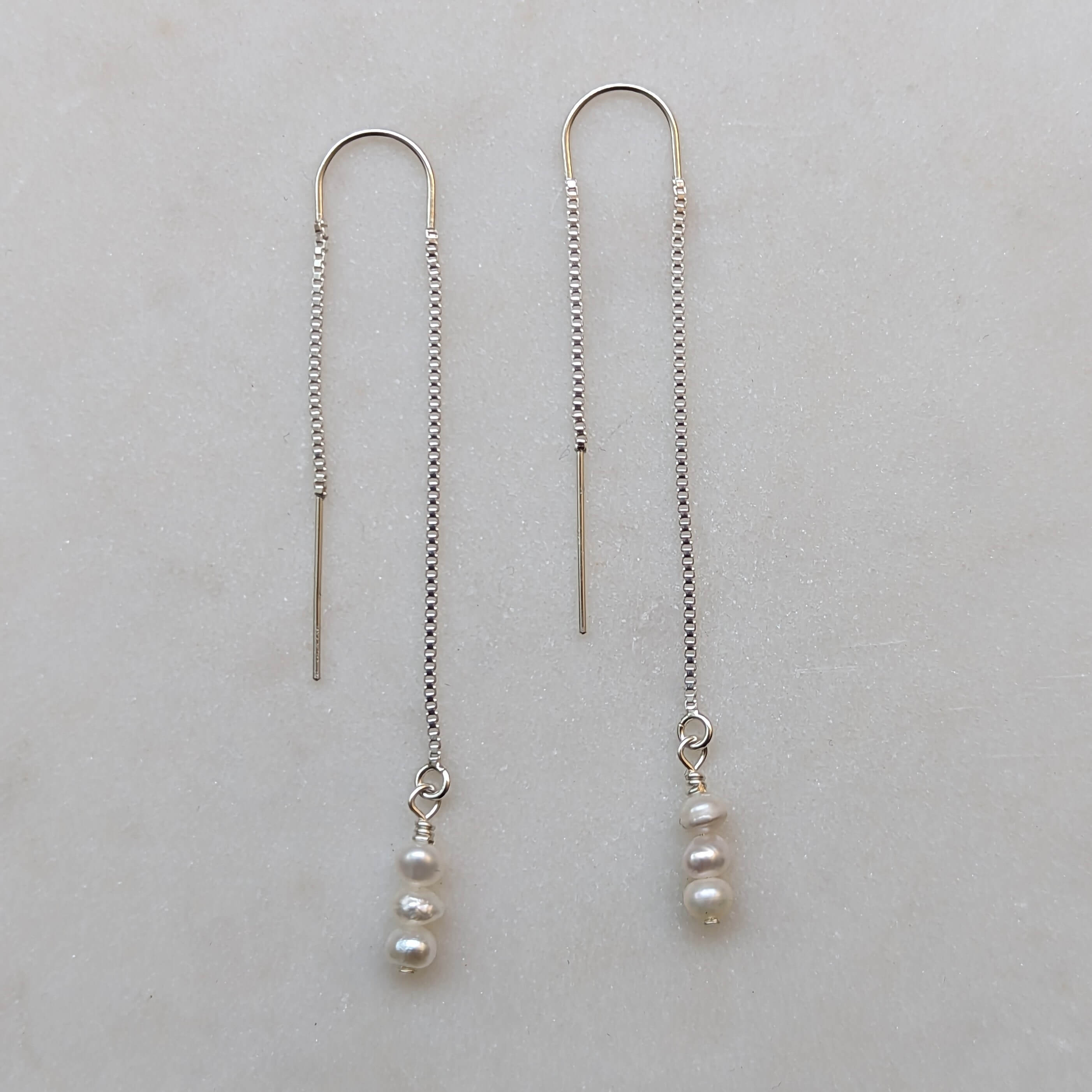 tiny pearl threader earrings in sterling silver flatlay