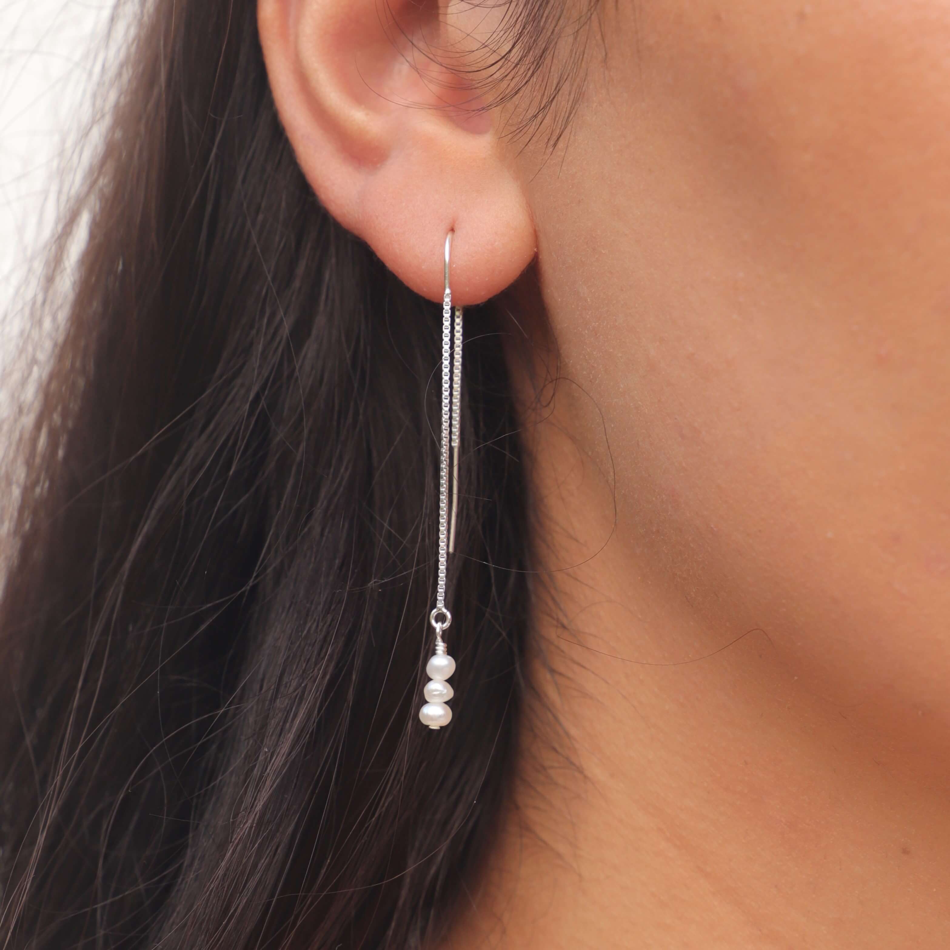 pearl threader earrings in sterling silver close up on model