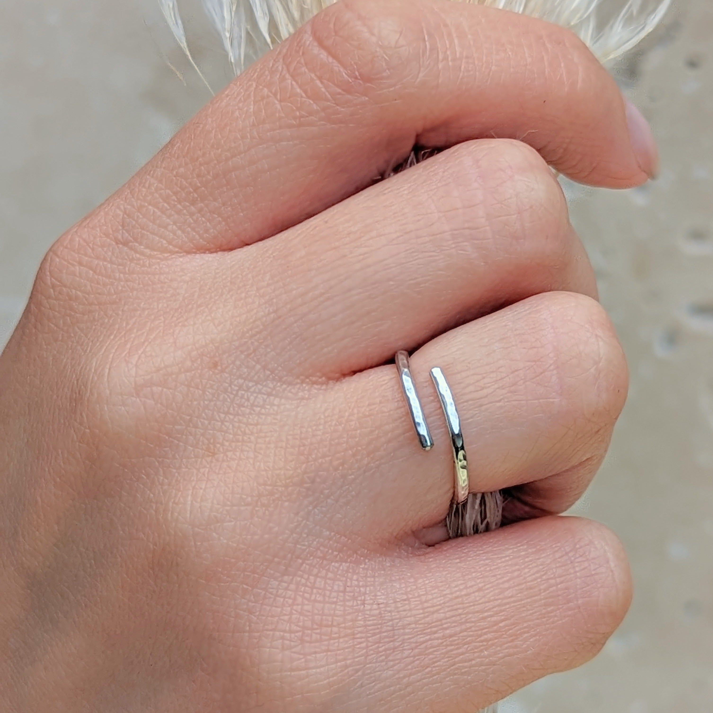 Close up of a hand holding dried florals and wearing a hammered silver adjustable ring