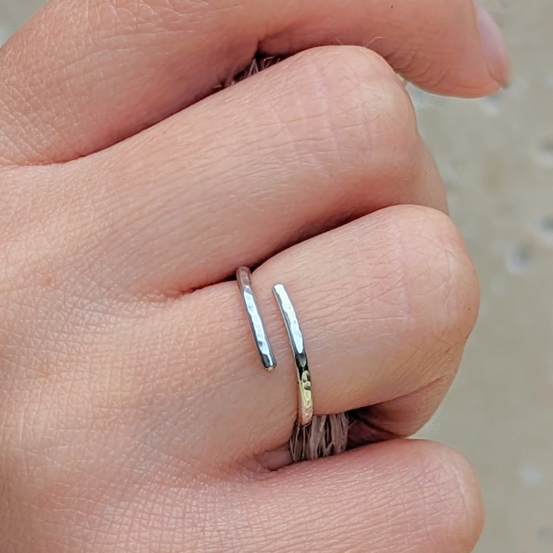 Close up of a hand holding dried florals and wearing a hammered silver adjustable ring