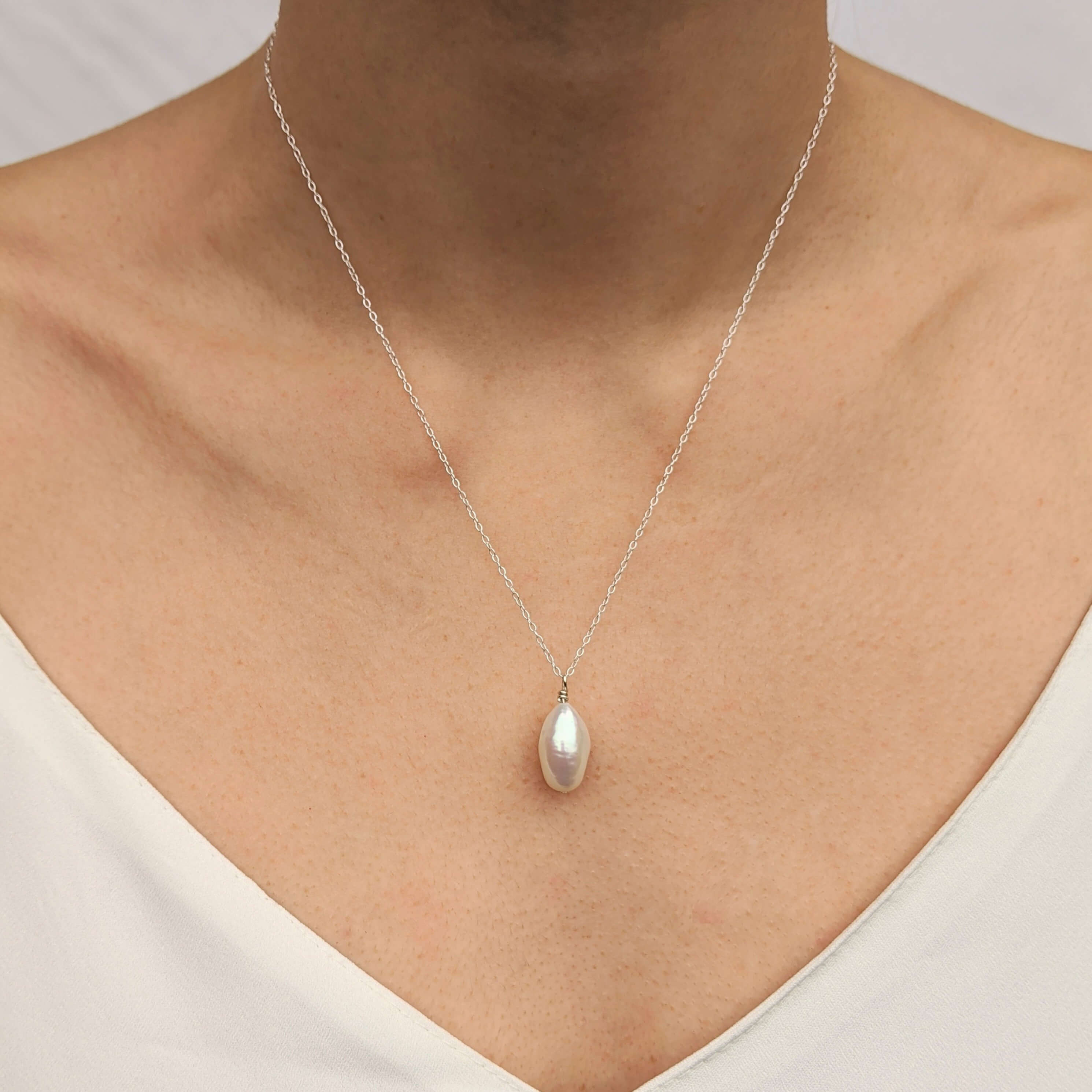 Model wearing sterling silver chain necklace with baroque pearl pendant