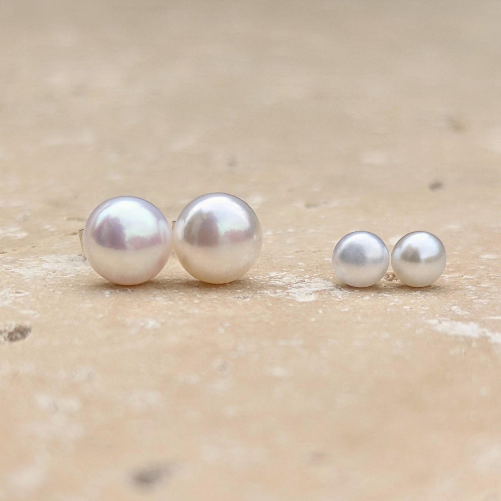 Size comparison between two pairs of round pearl earrings