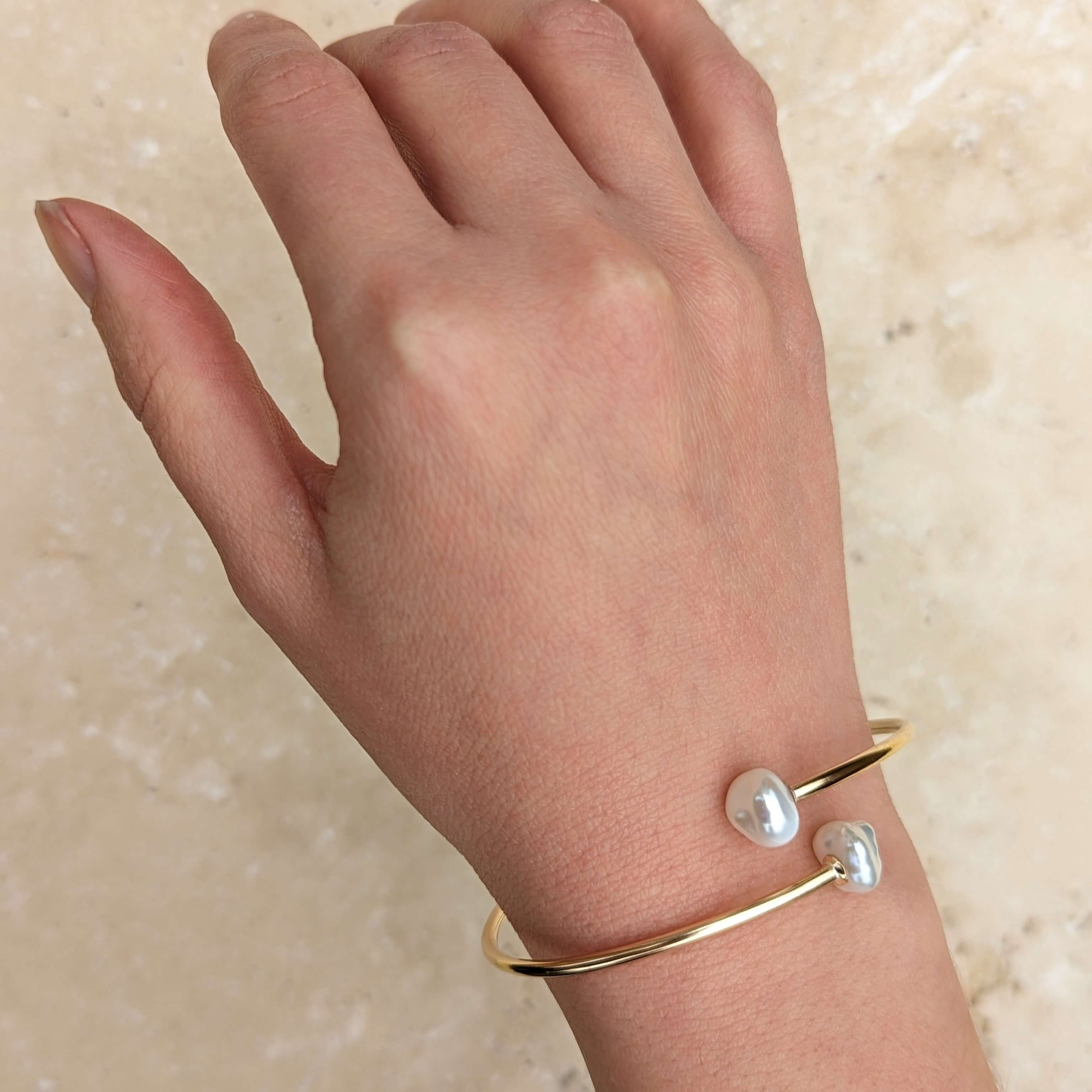 Wrist wearing flexible pearl bypass bangle in gold