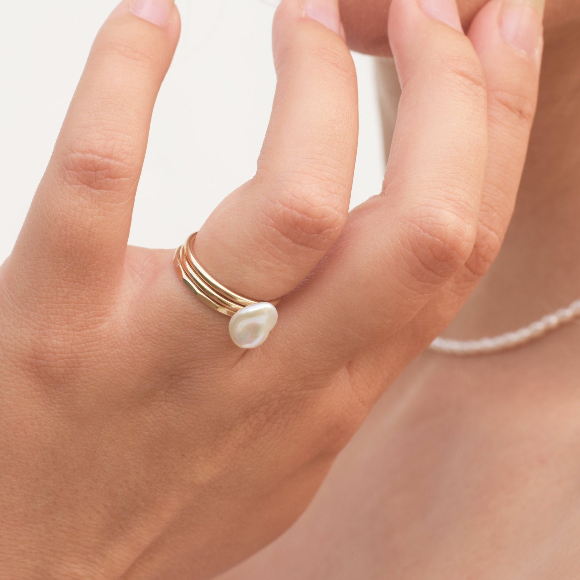 trio of pearl and gold filled stacking rings on hand