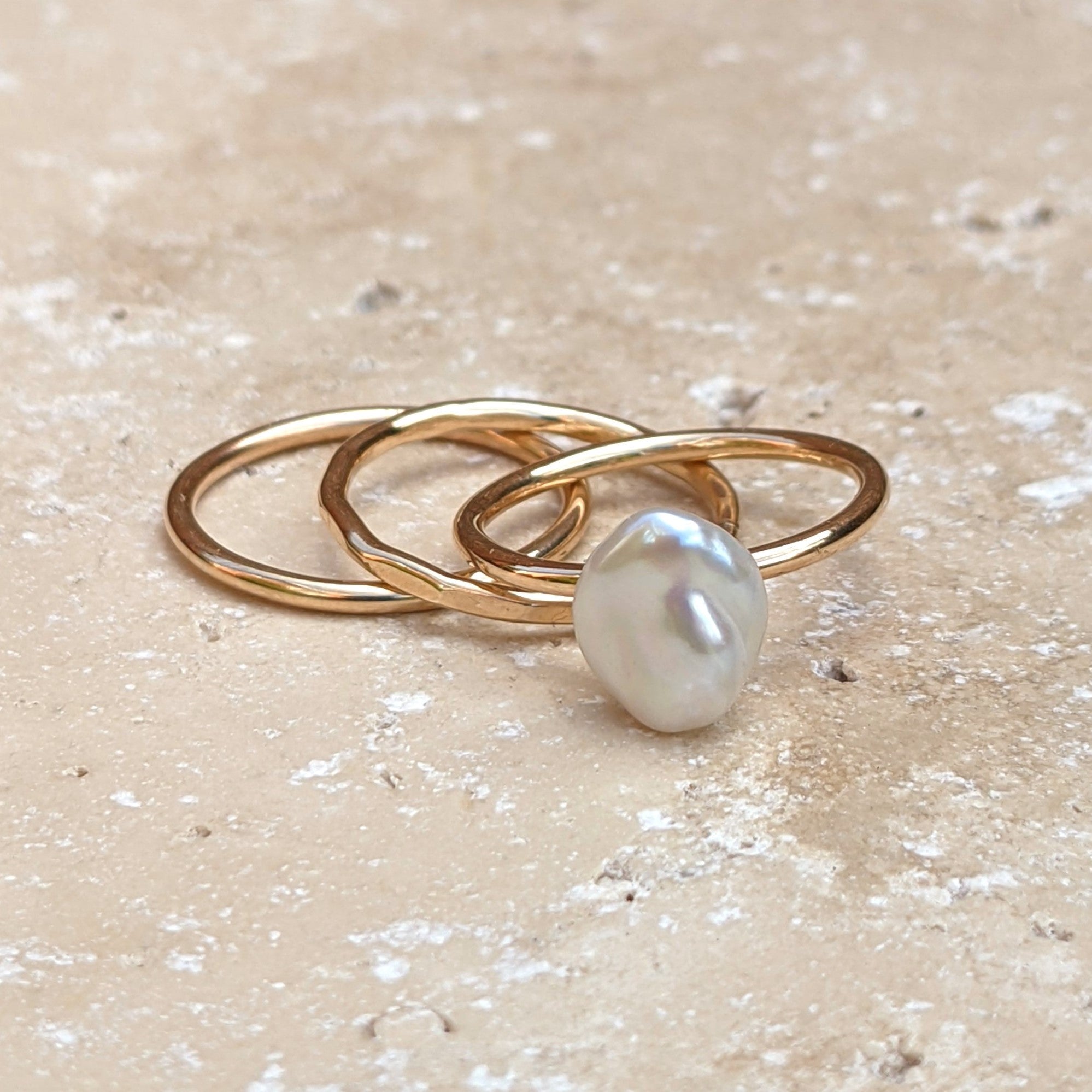 A trio of gold filled stacking rings - plain, hammered and pearl