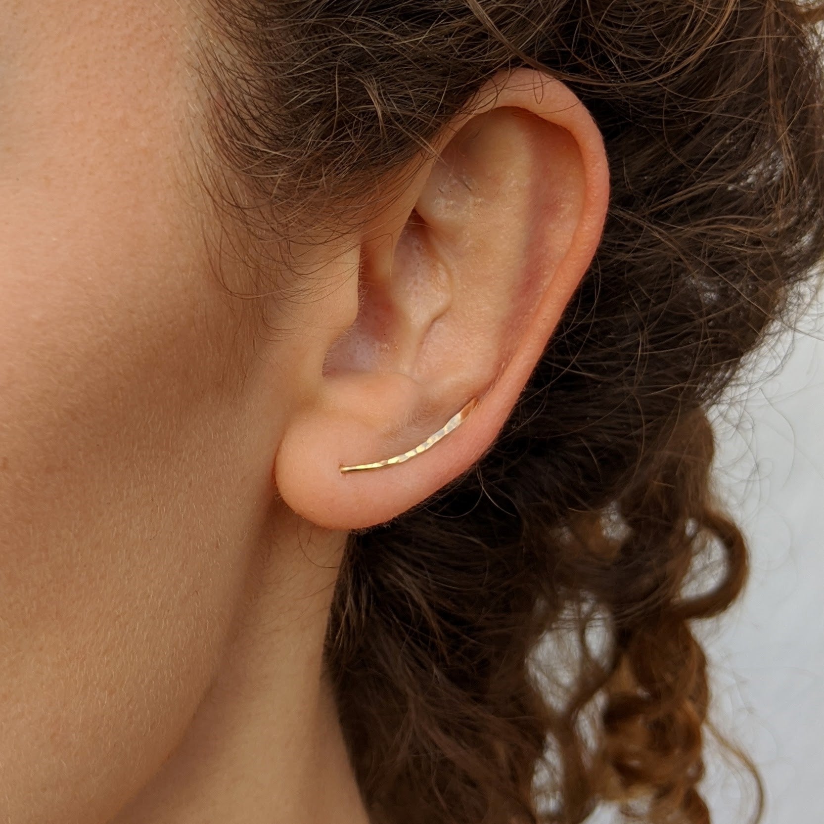 Model wearing Grace climber earrings in gold closeup