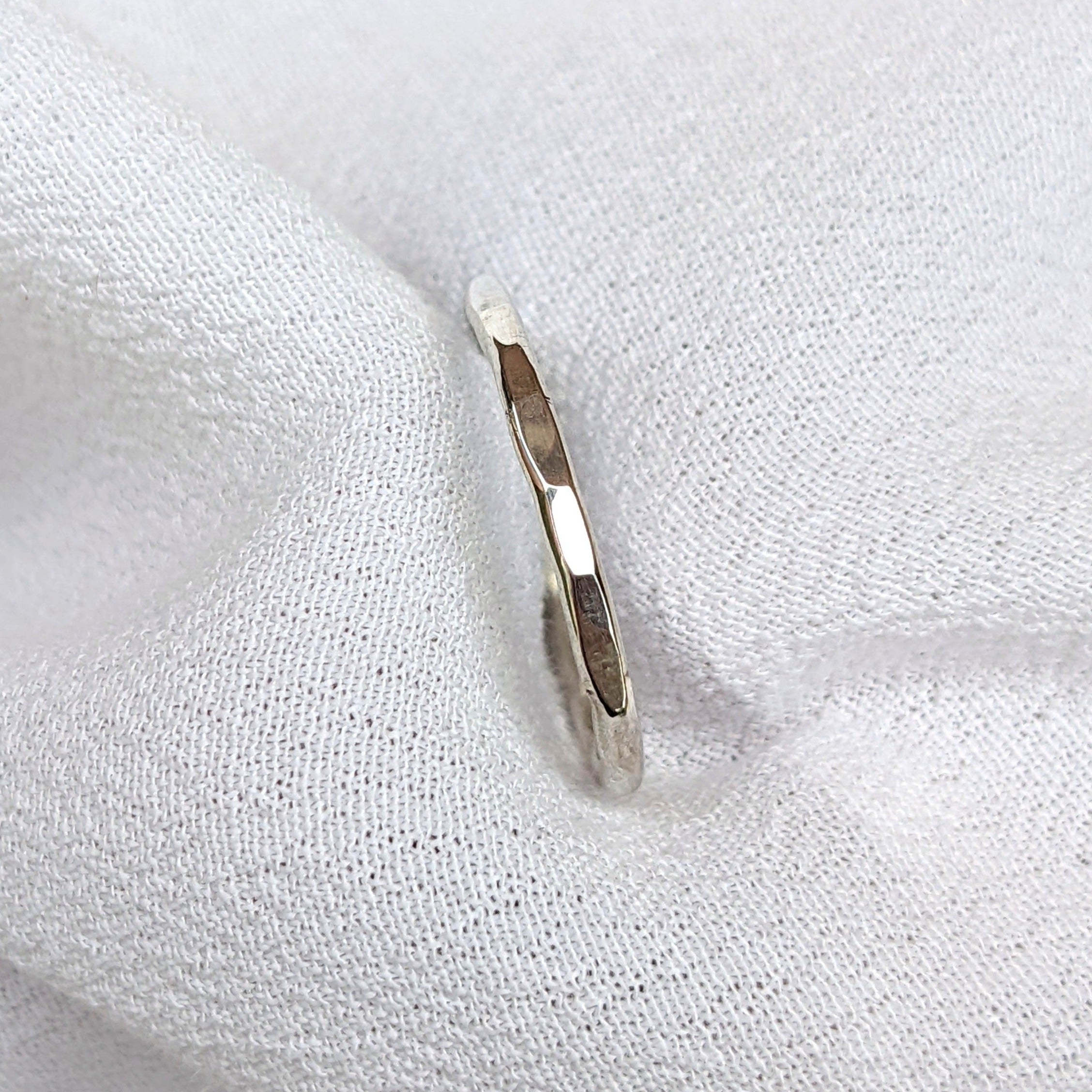 Hammered sterling silver ring held in white fabric