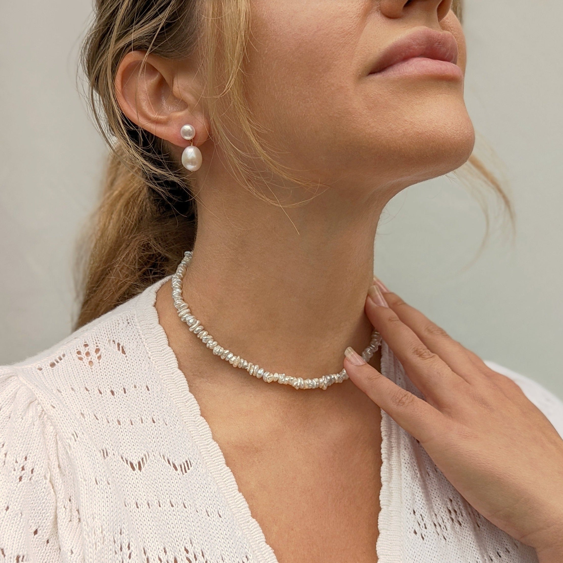 Model wearing pearl drop earrings and necklace