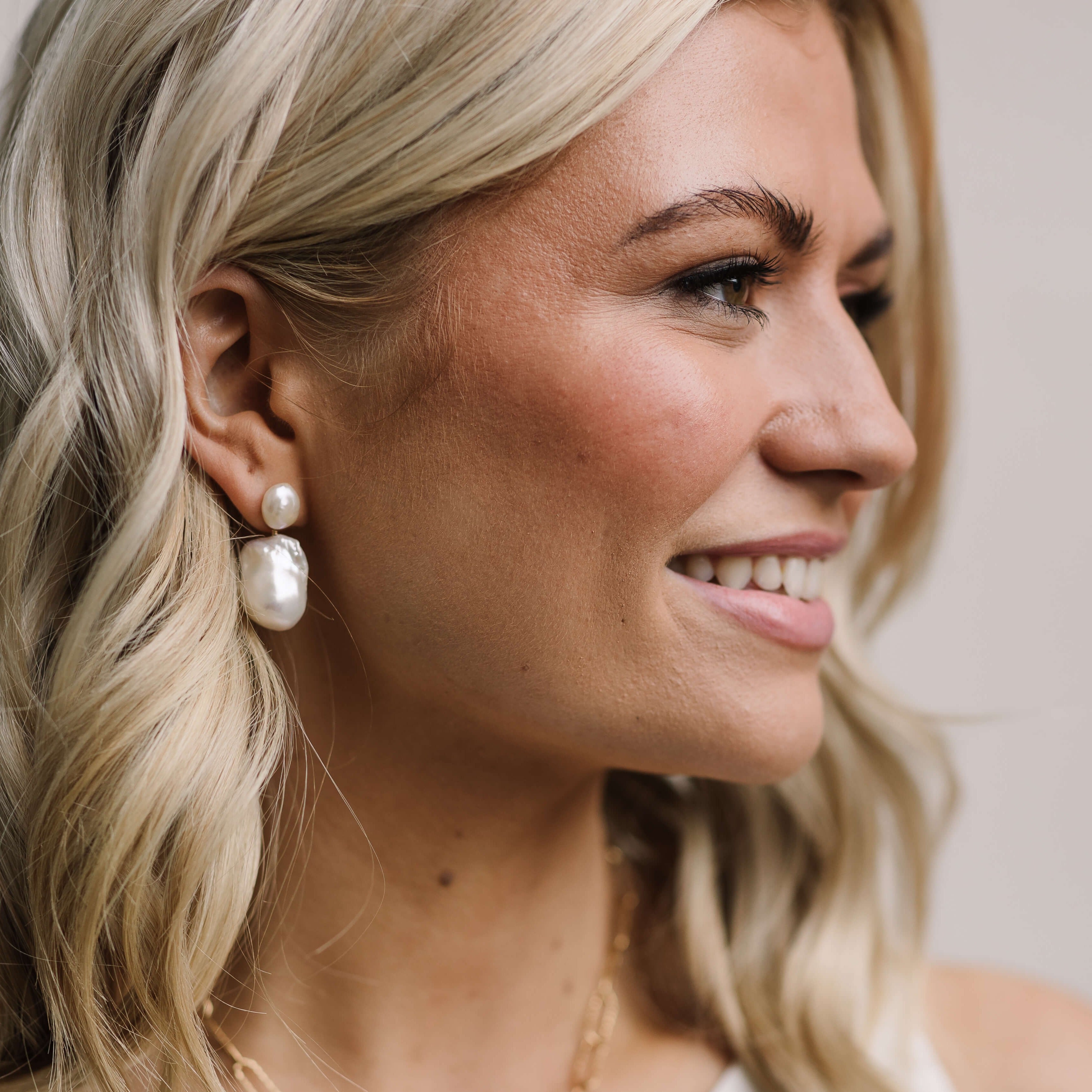 woman wearing large baroque pearl drop earrings