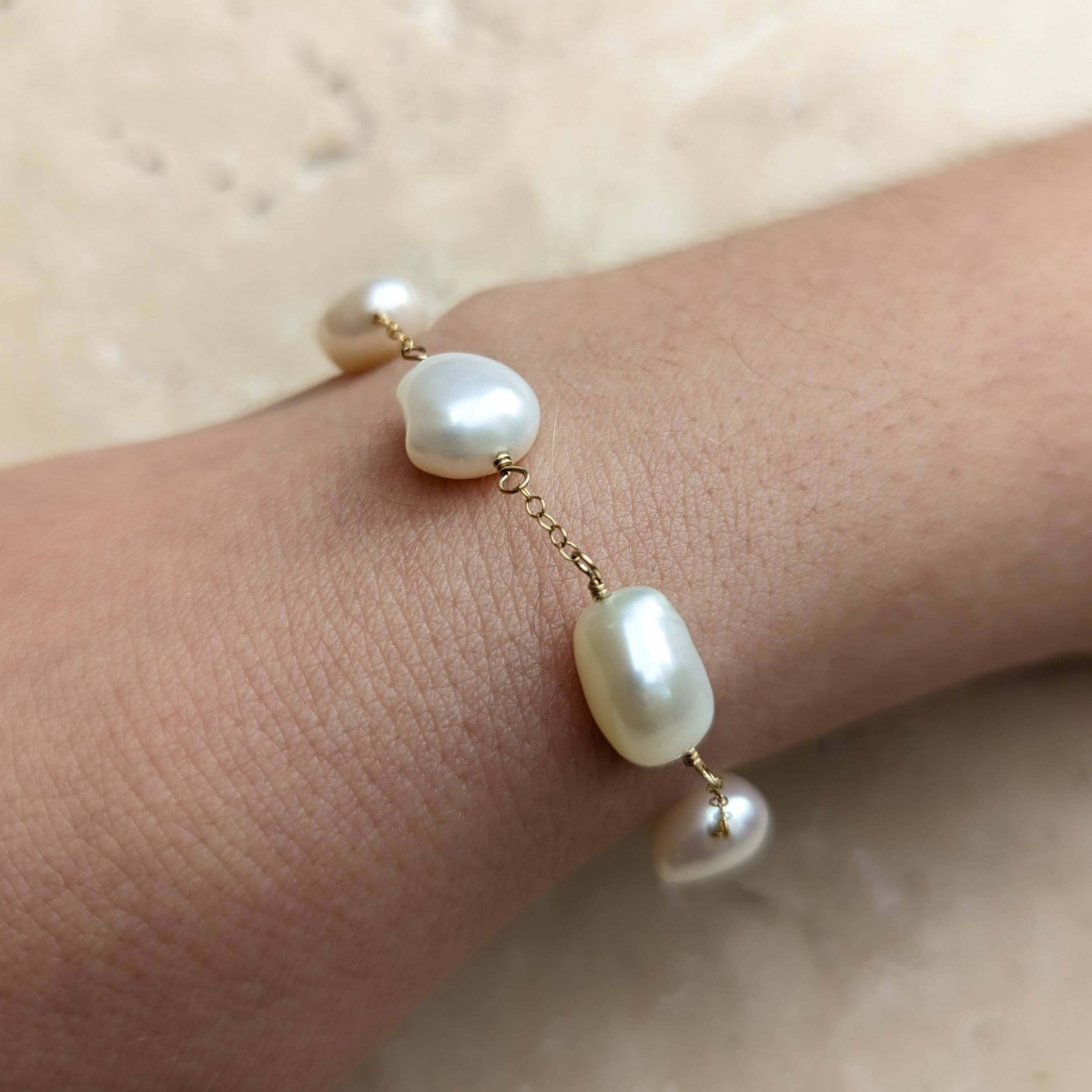 Close up of pearl chain bracelet on model wrist in gold filled
