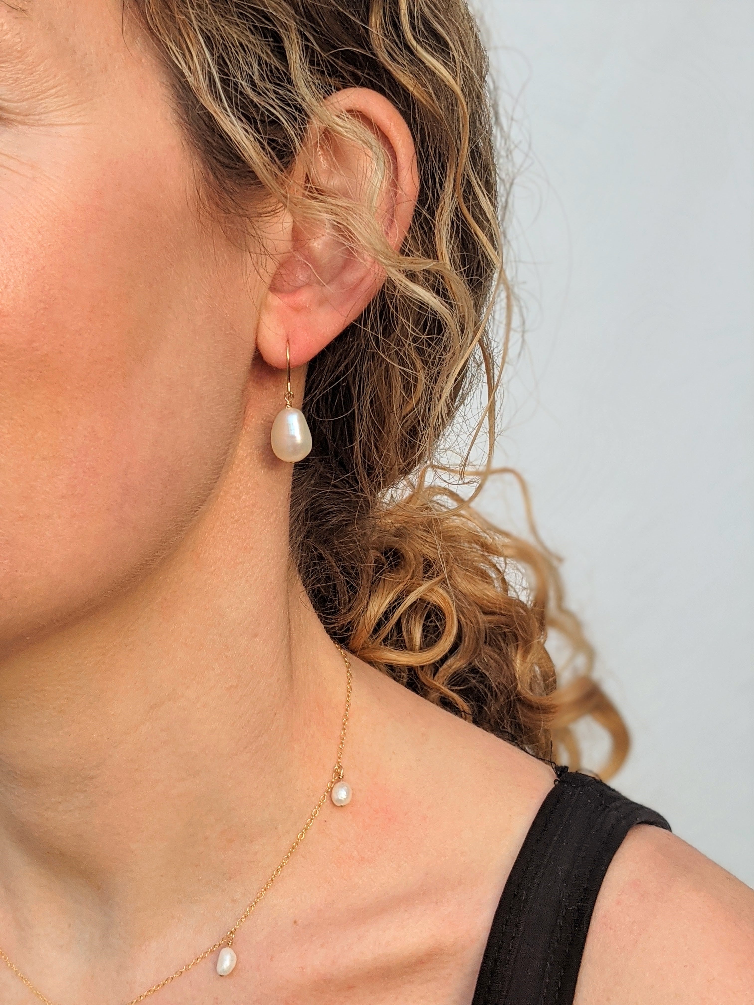 closeup of model wearing pearl hook earrings