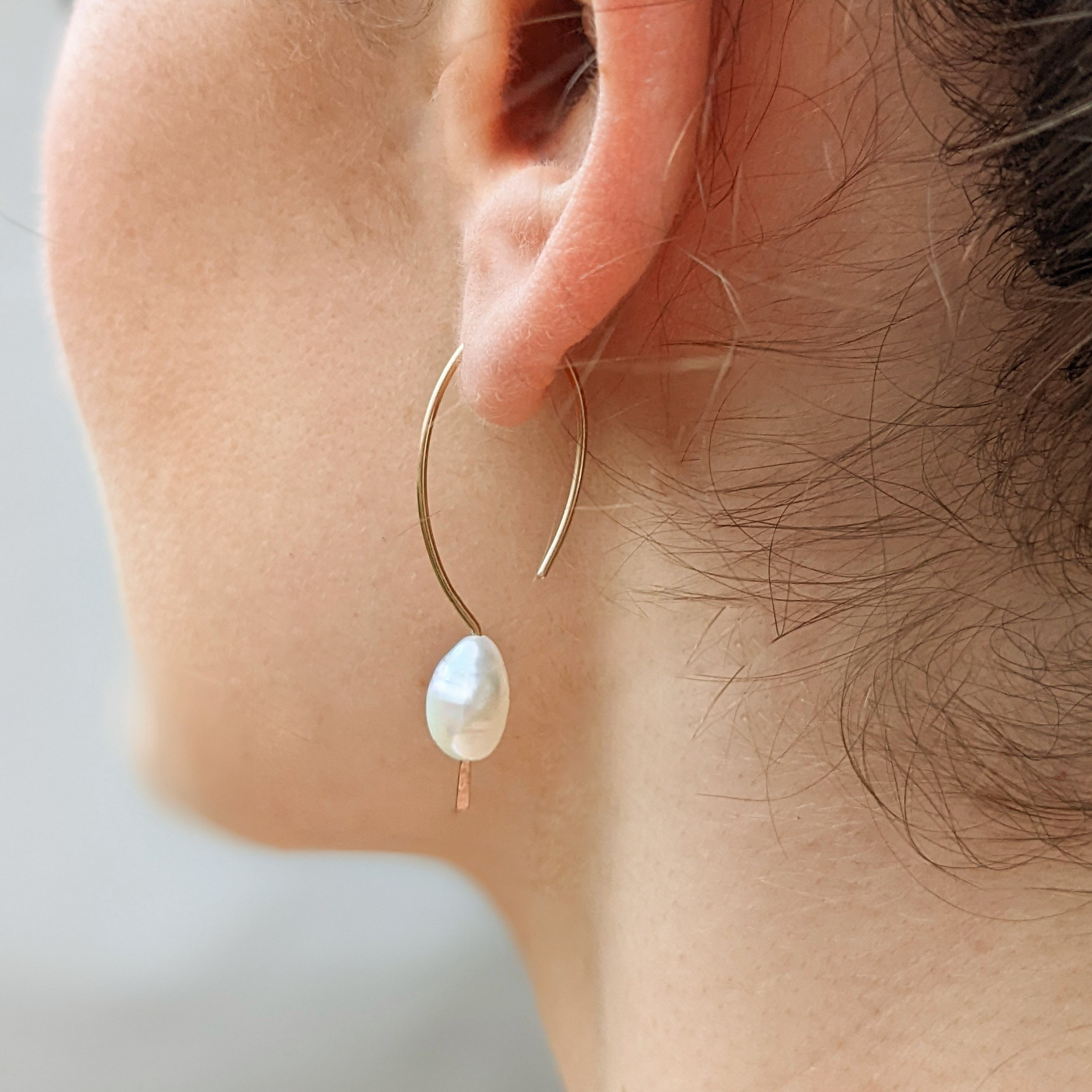 Pearl pull through earrings gold on ear