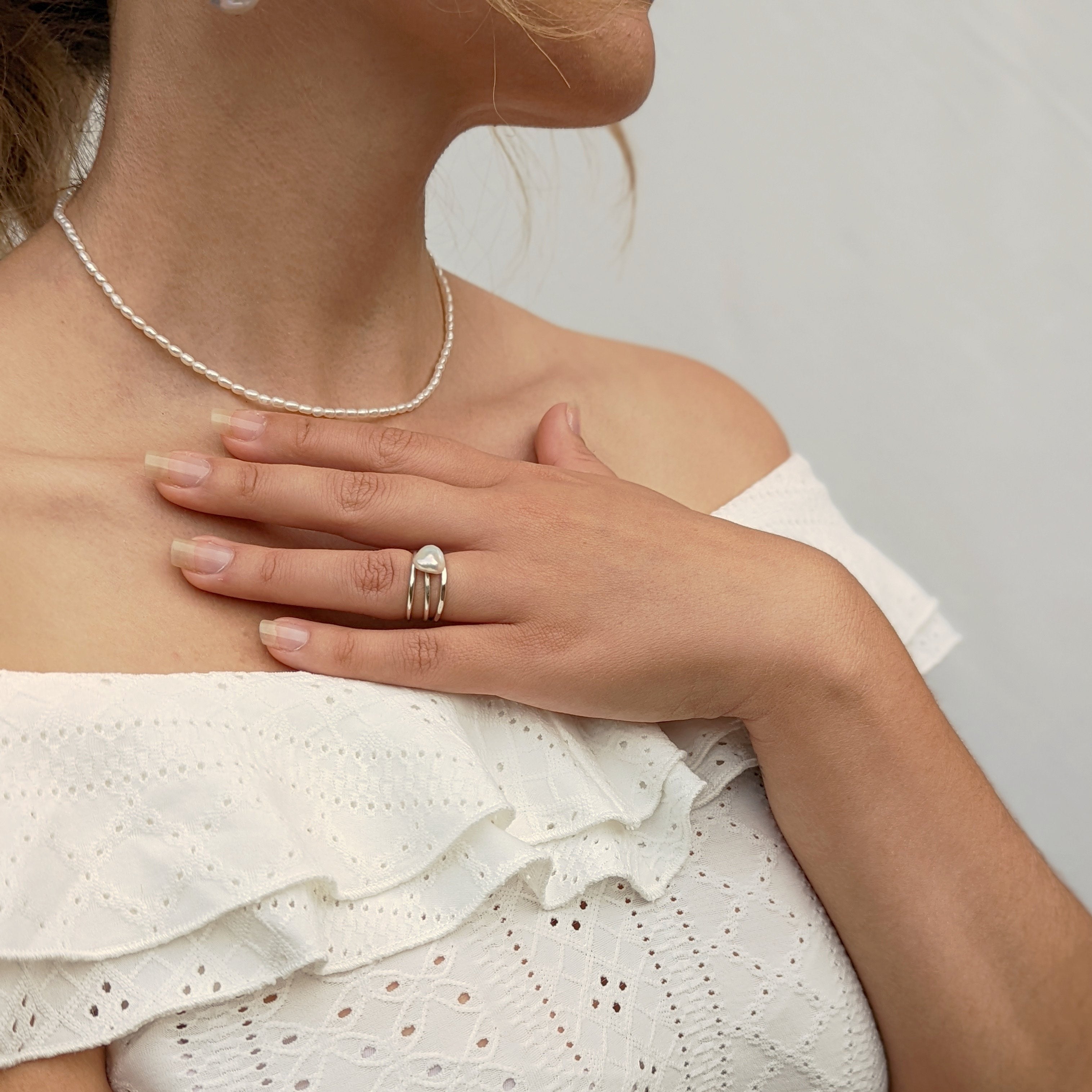 Model wearing small pearl necklace and pearl ring