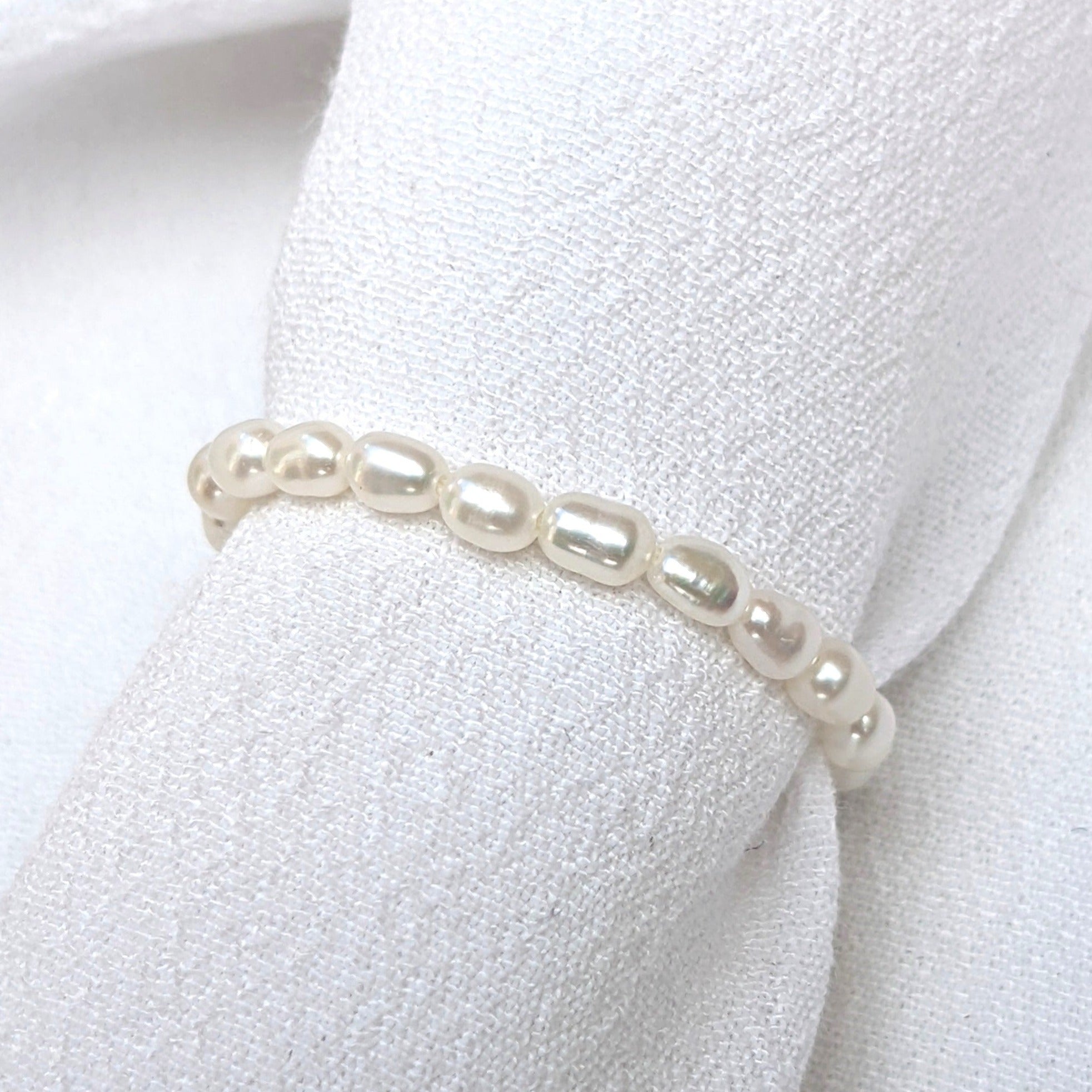 Seed pearl ring on  white fabric