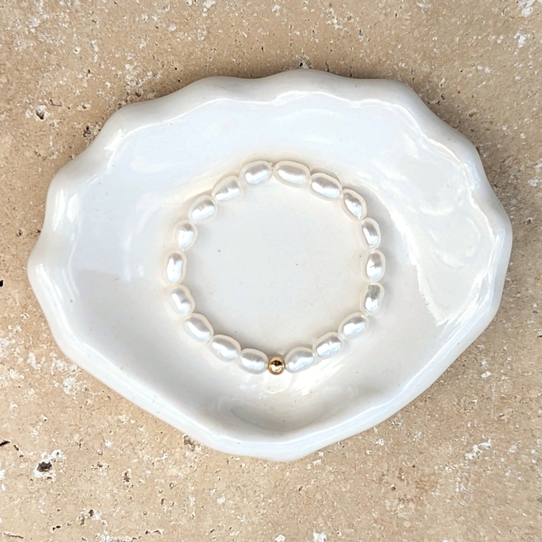Shell shaped dish with a pearl ring with a small gold bead