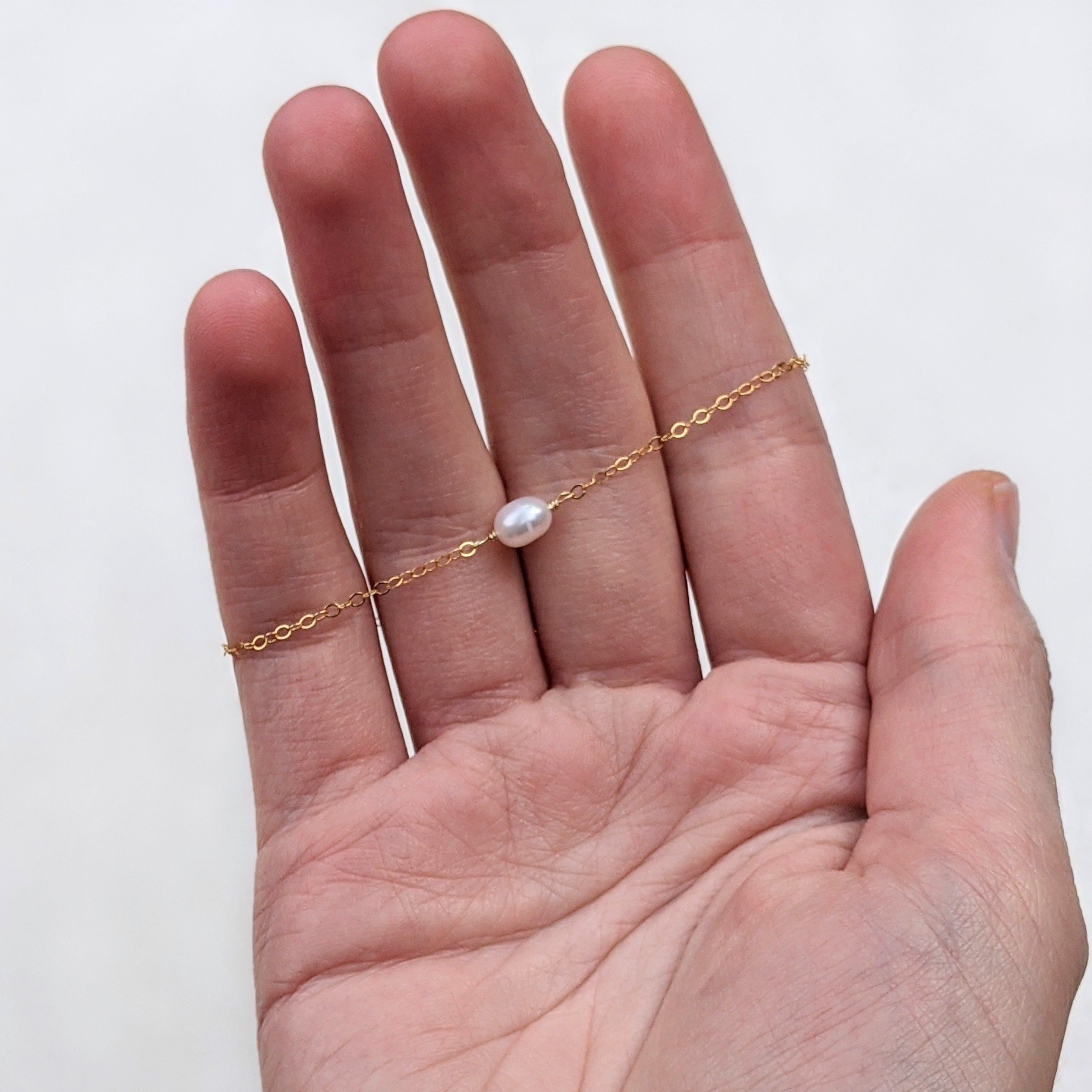Single pearl bracelet in a hand