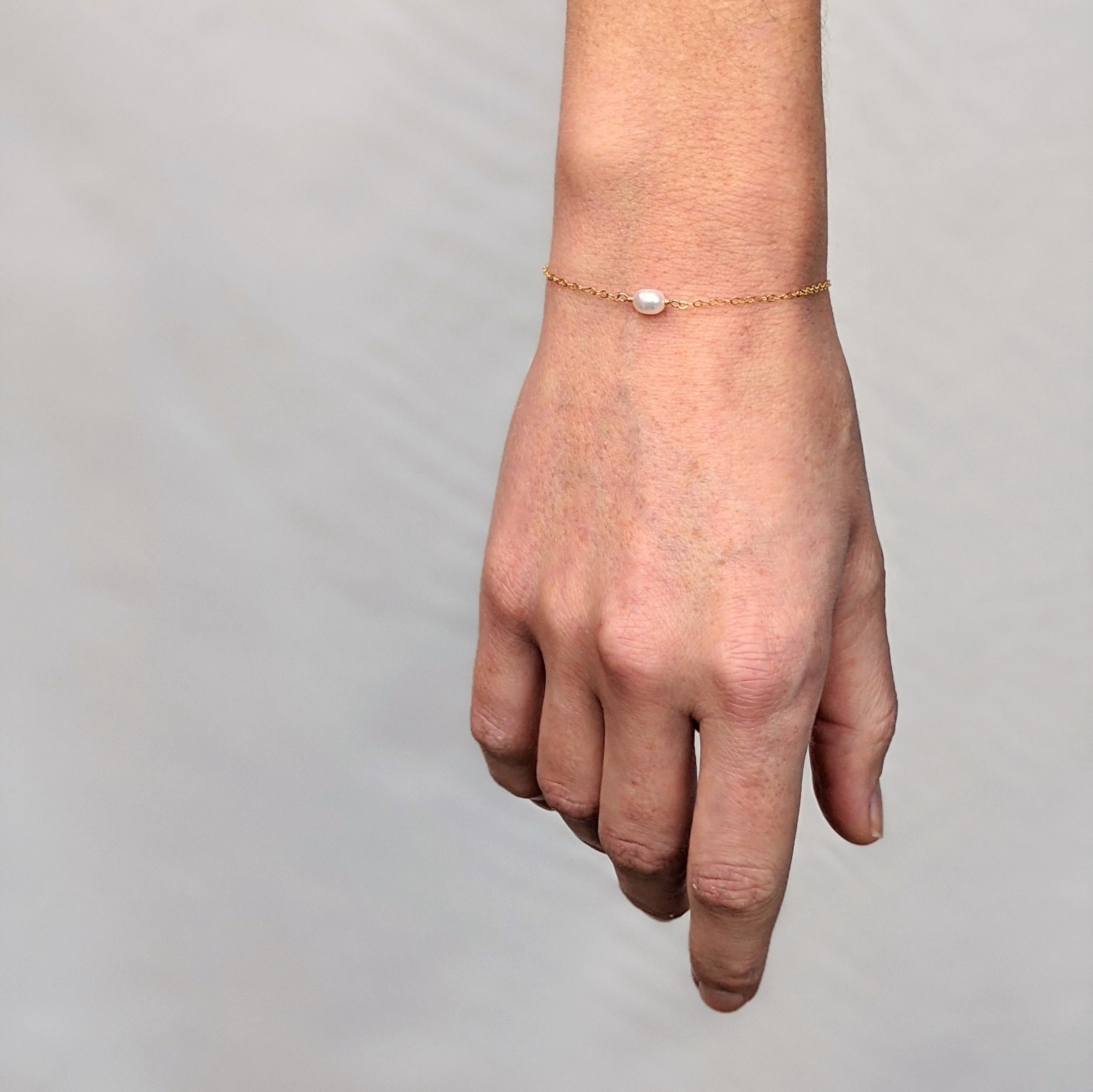 Single pearl bracelet on a wrist