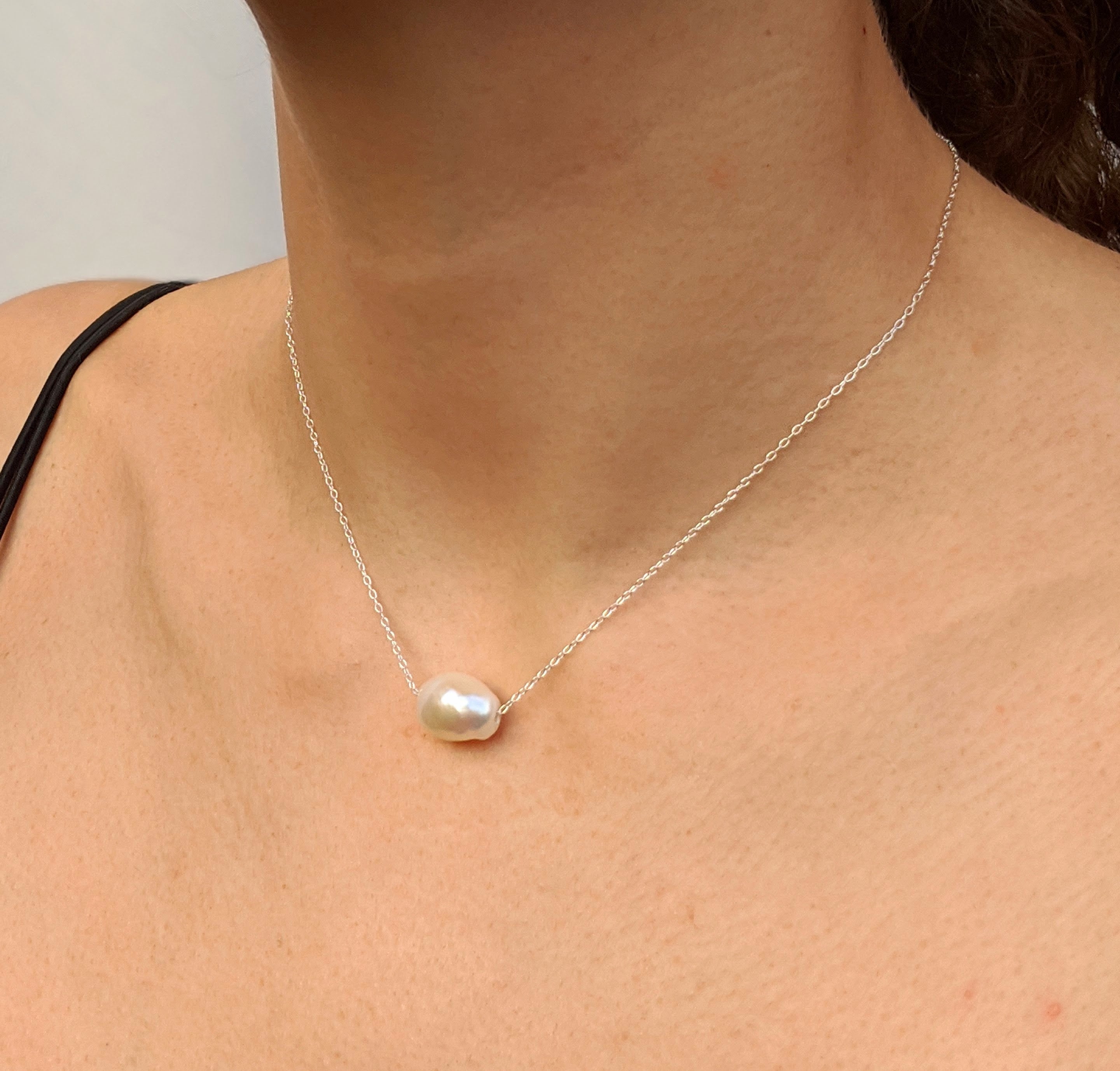 Single sideways large pearl silver necklace on a model