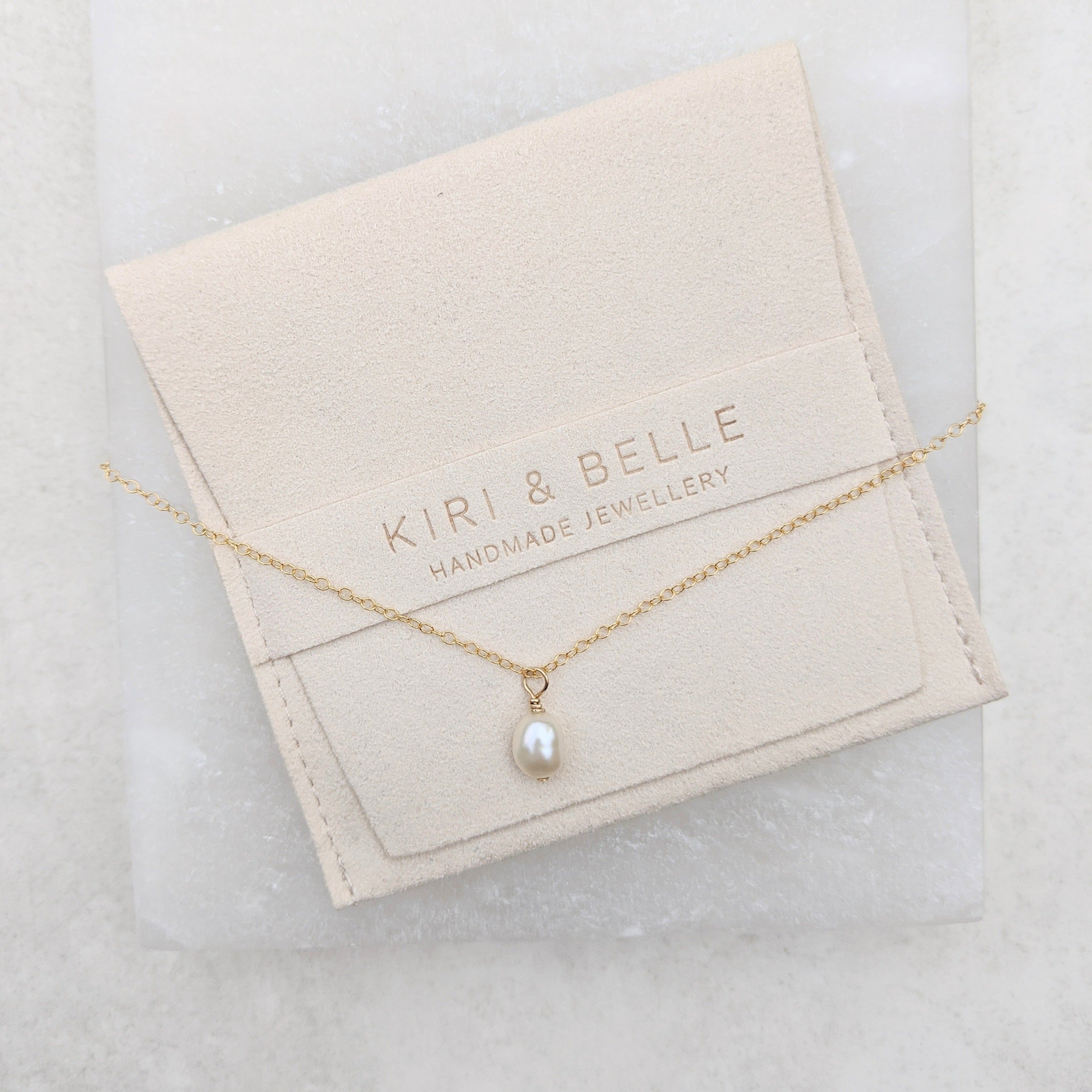 Baroque pearl pendant gold necklace on Kiri and Belle suede pouch