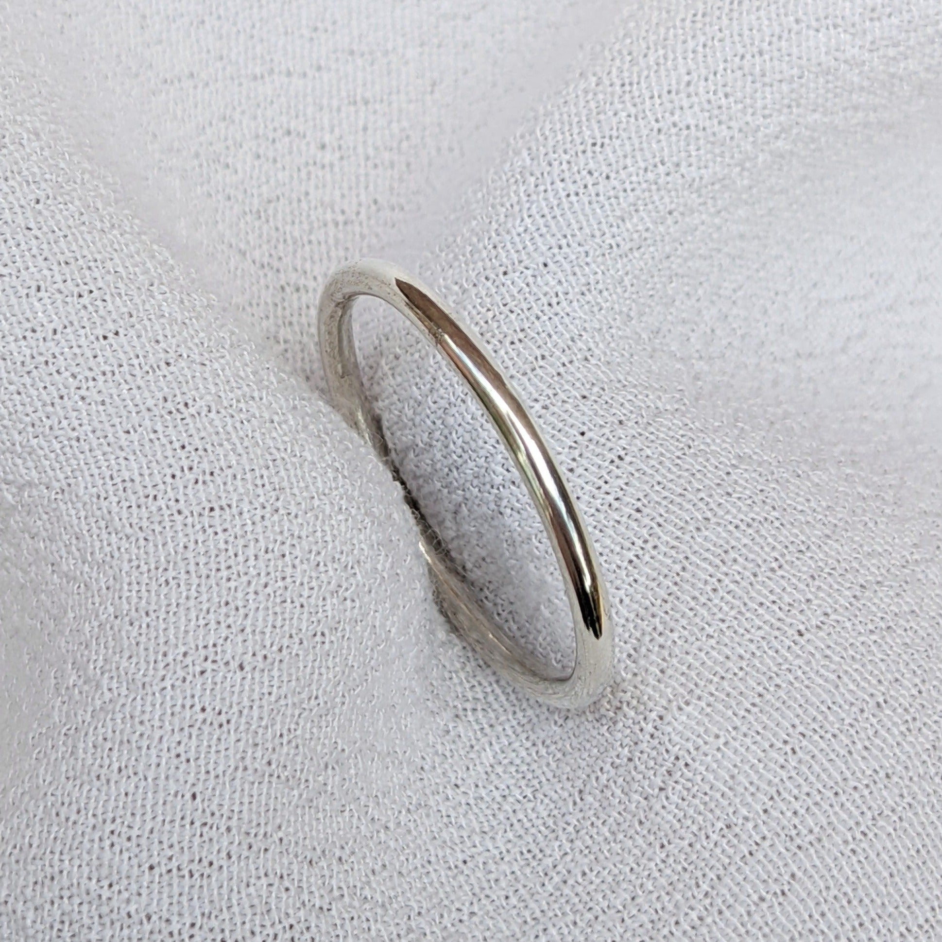 Slim silver ring held in white fabric
