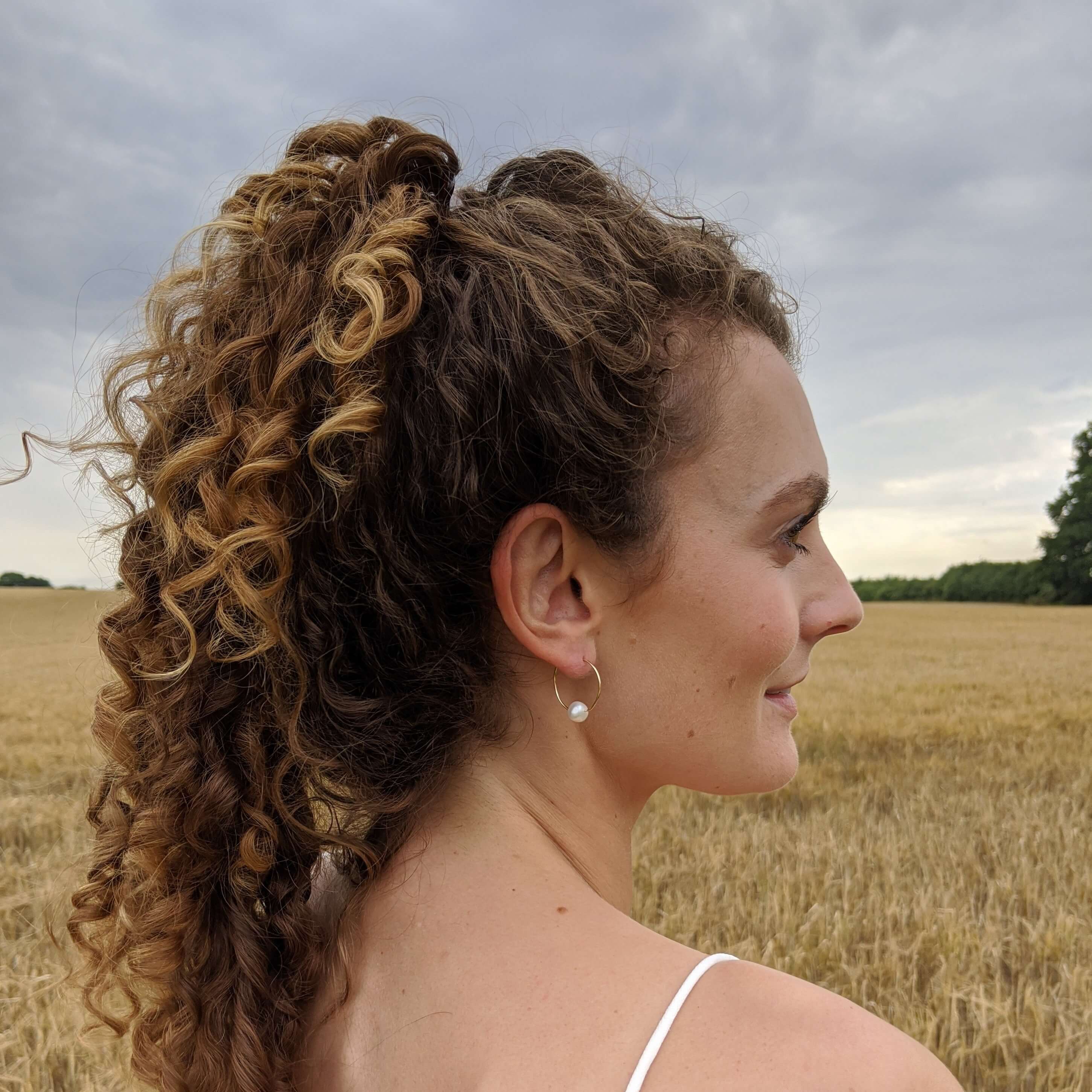 gold filled wire earrings on model right side